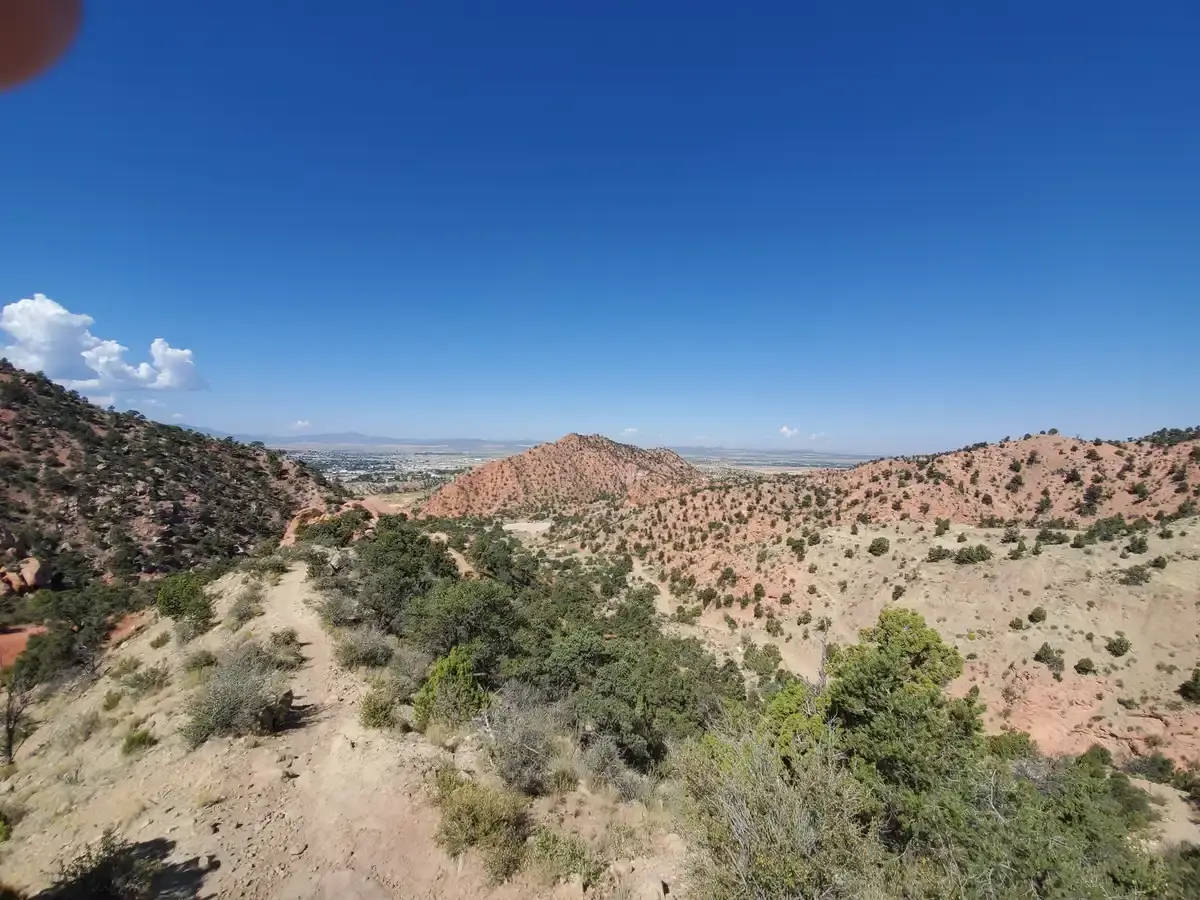 An expansive view of arid, rolling hills covered in sparse green vegetation.