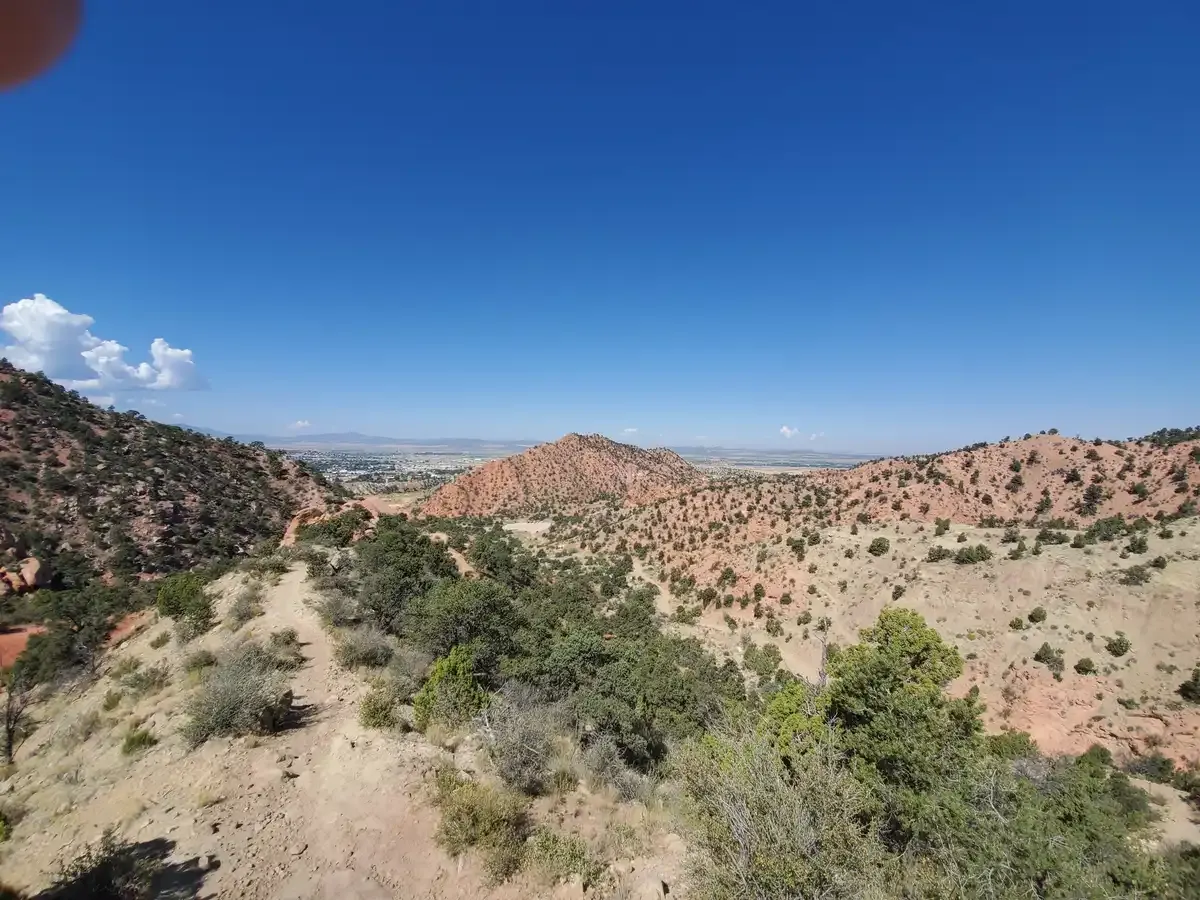 An expansive view of arid, rolling hills covered in sparse green vegetation. - Lightning Switch and Ghost Flats Loop