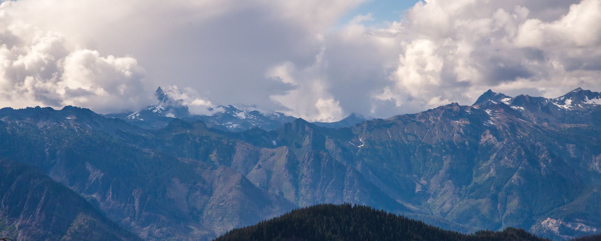 Panoramic view of rugged mountains with snow-capped peaks under a cloudy sky. - Basalt Peak loop via Basalt Ridge Trail