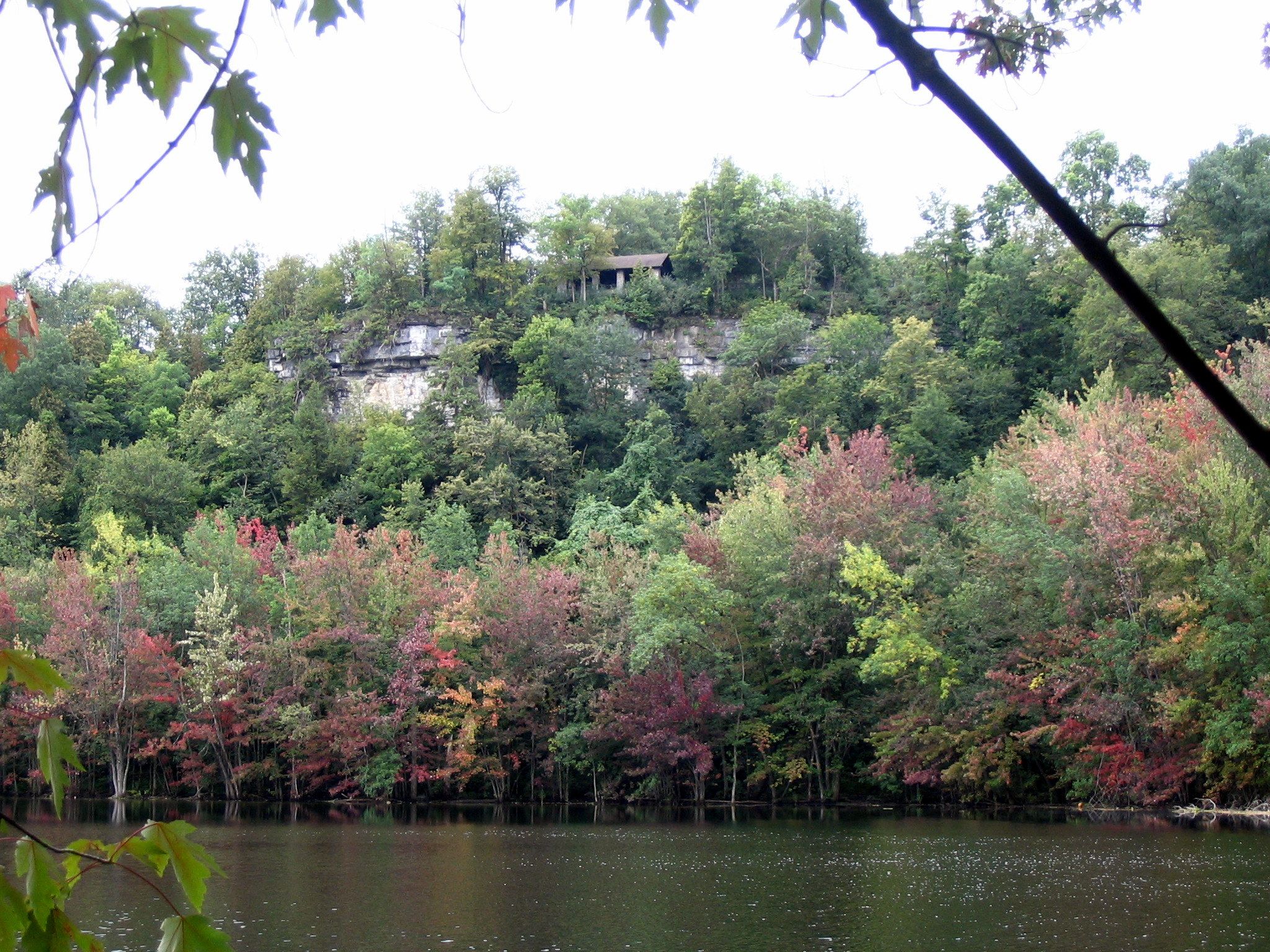 Overcast view of a lake, autumn trees, and a building on a rocky cliff. - Cherry Valley Turnpike,  Eagle Road,  and Clark State Park Reservation loop