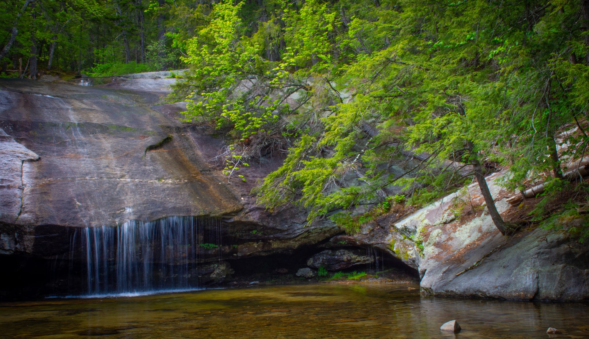 Waterfall cascades over a rocky cliff into a calm pool, surrounded by green trees. - Beede Falls – Sandwich Town Beach loop from Metcalf Preserve