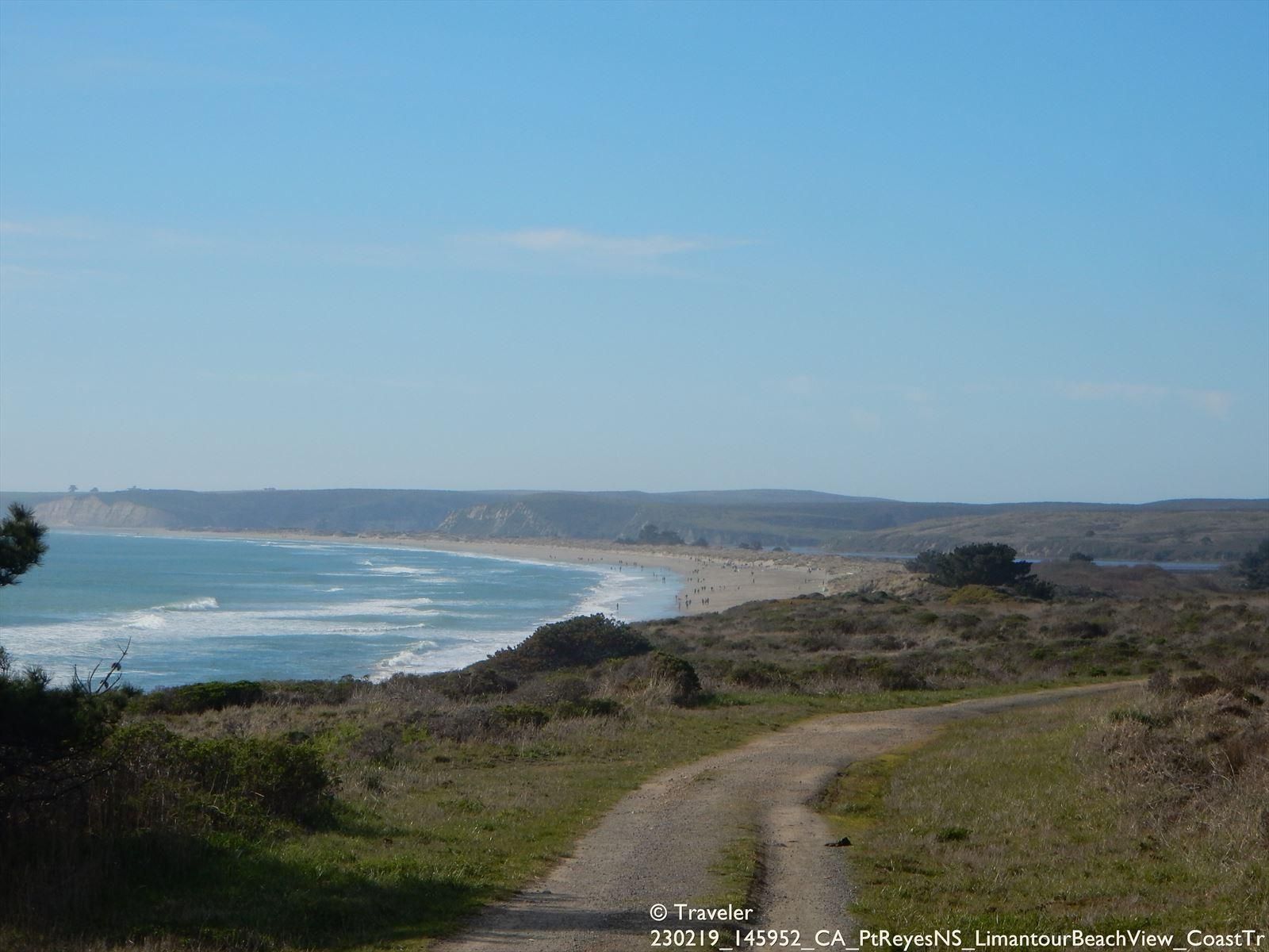 Dirt road leading to a sunny coastal beach with waves and grassy hills. - Laguna and Coast Trail loop