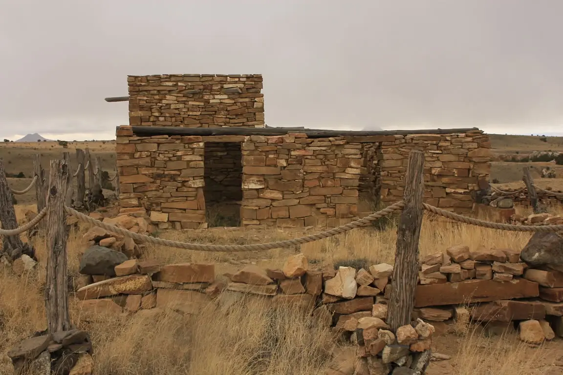 Ancient stone ruins in an arid landscape under an overcast sky.