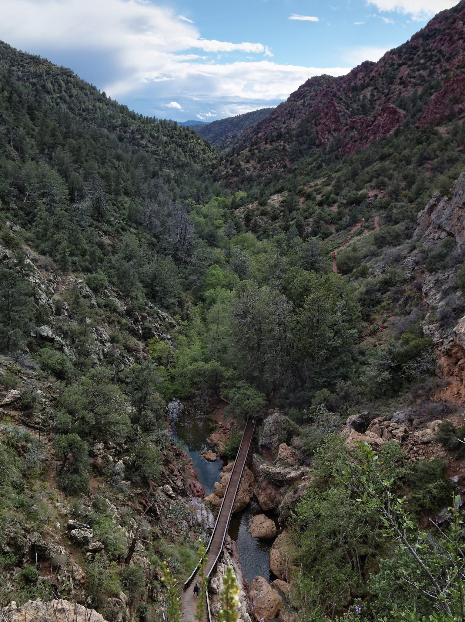 Scenic canyon view with a long bridge over a river, partly cloudy sky. - Pine Creek, Anna Mae, Gowan, and Waterfall Loop
