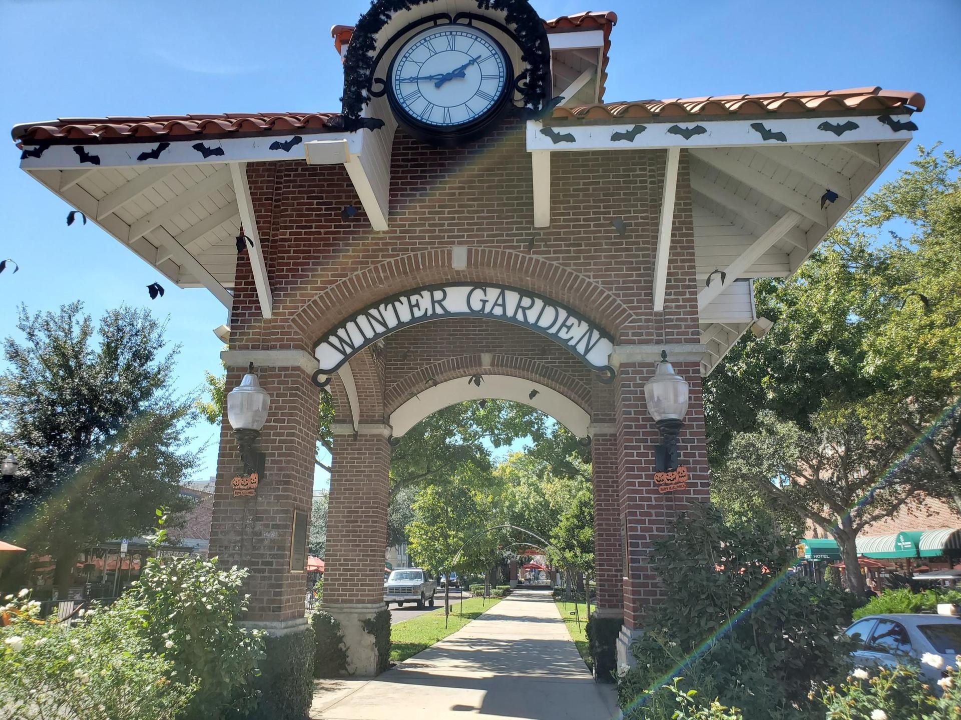 A brick archway with a clock tower and a sign reading 'WINTER GARDEN'.