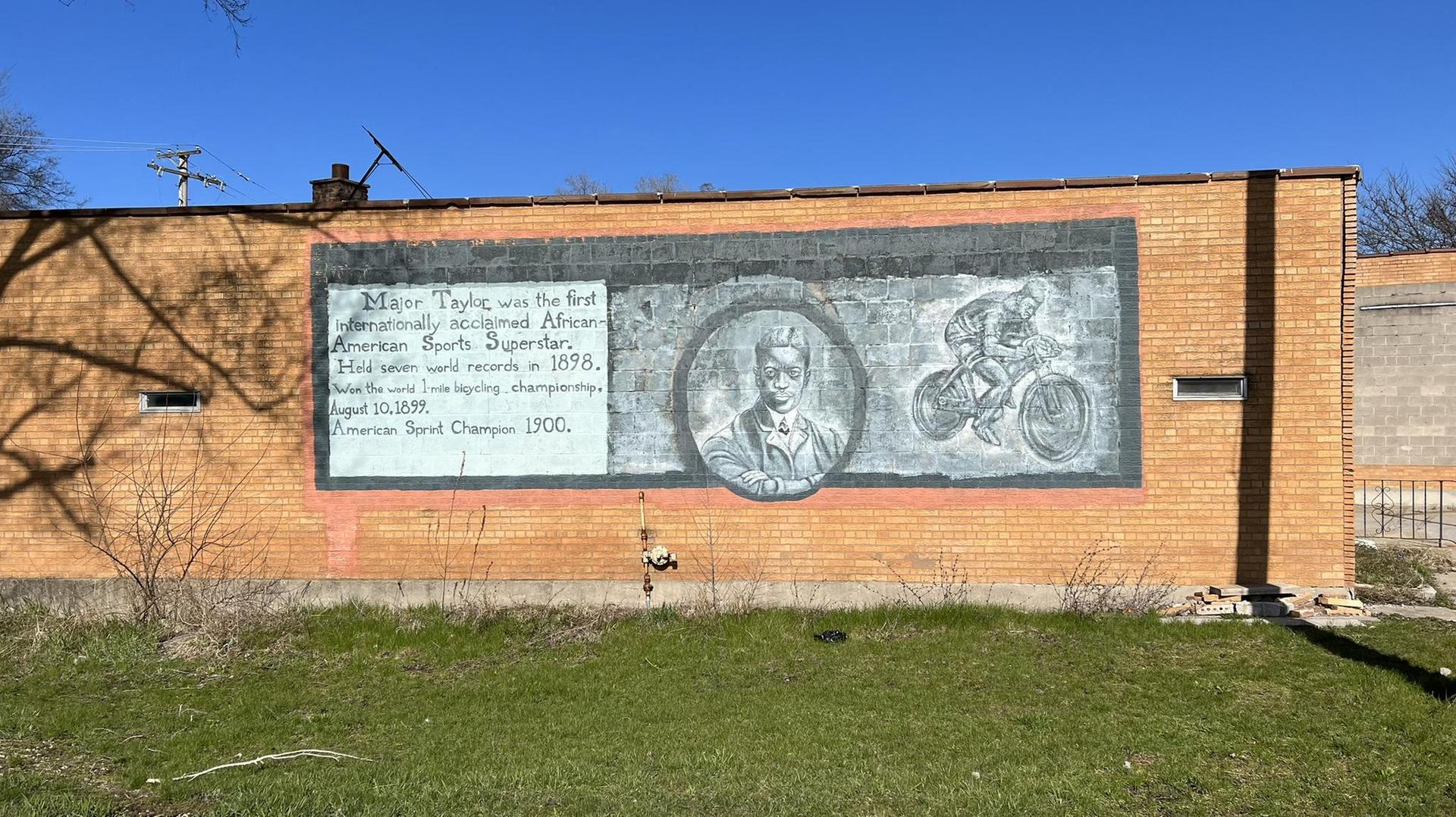 Bright mural on a brick wall depicting a person and a bicycle.