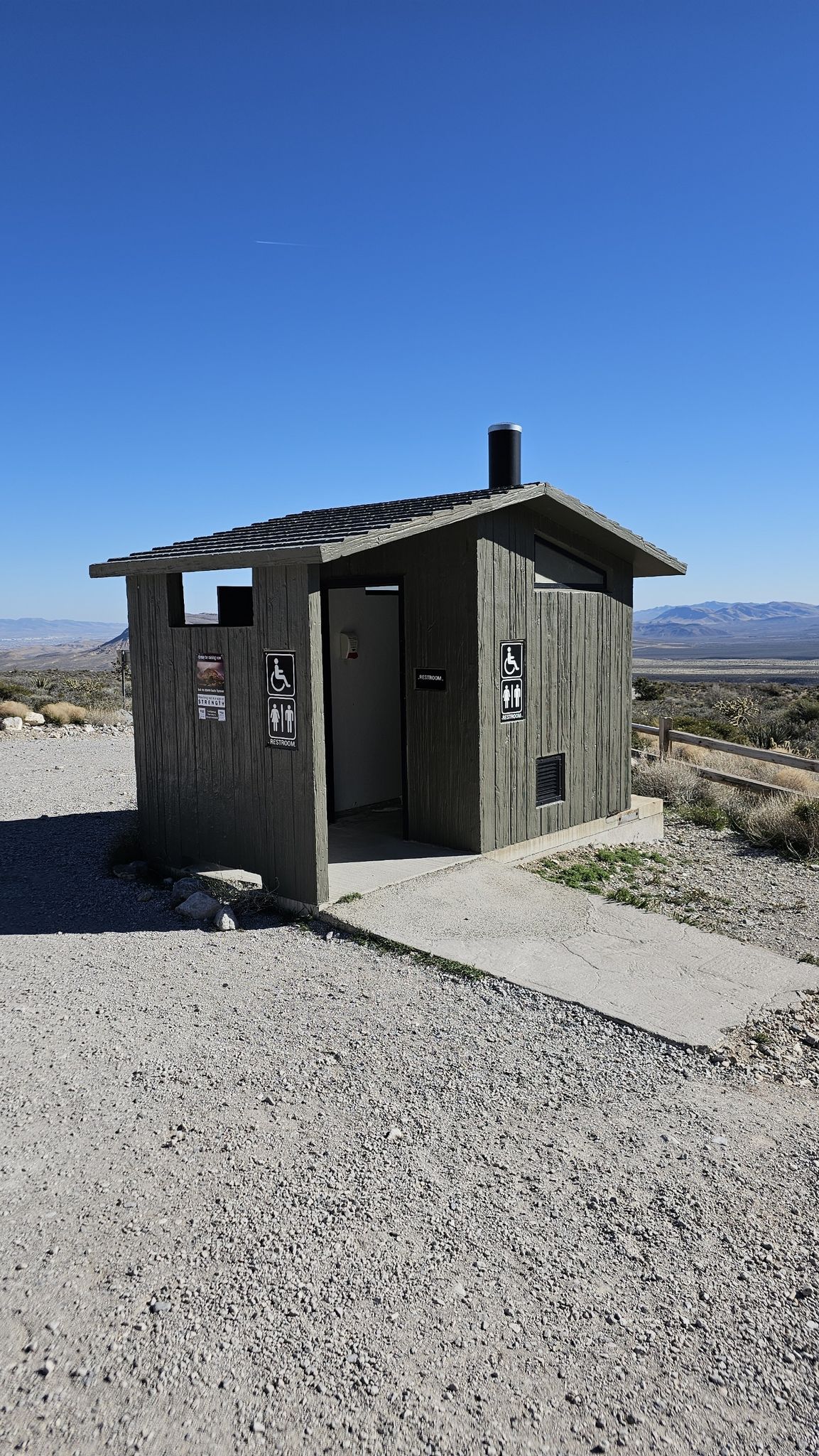 A small, gray wooden outhouse building under a clear blue sky. - Grand Circle, Turtlehead Peak, and White Rock Loop