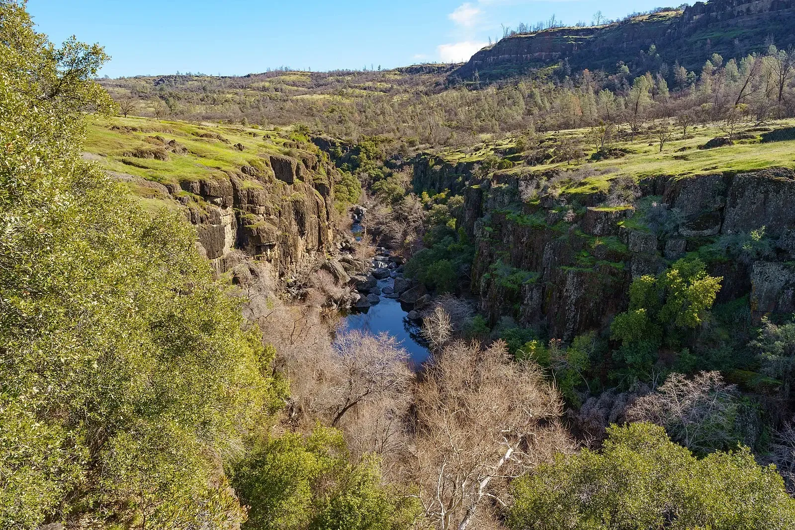 A river winds through a deep, rocky canyon under bright daylight. - Cliffs over Big Chico Creek – Bidwell Park loop from Goose Neck Park