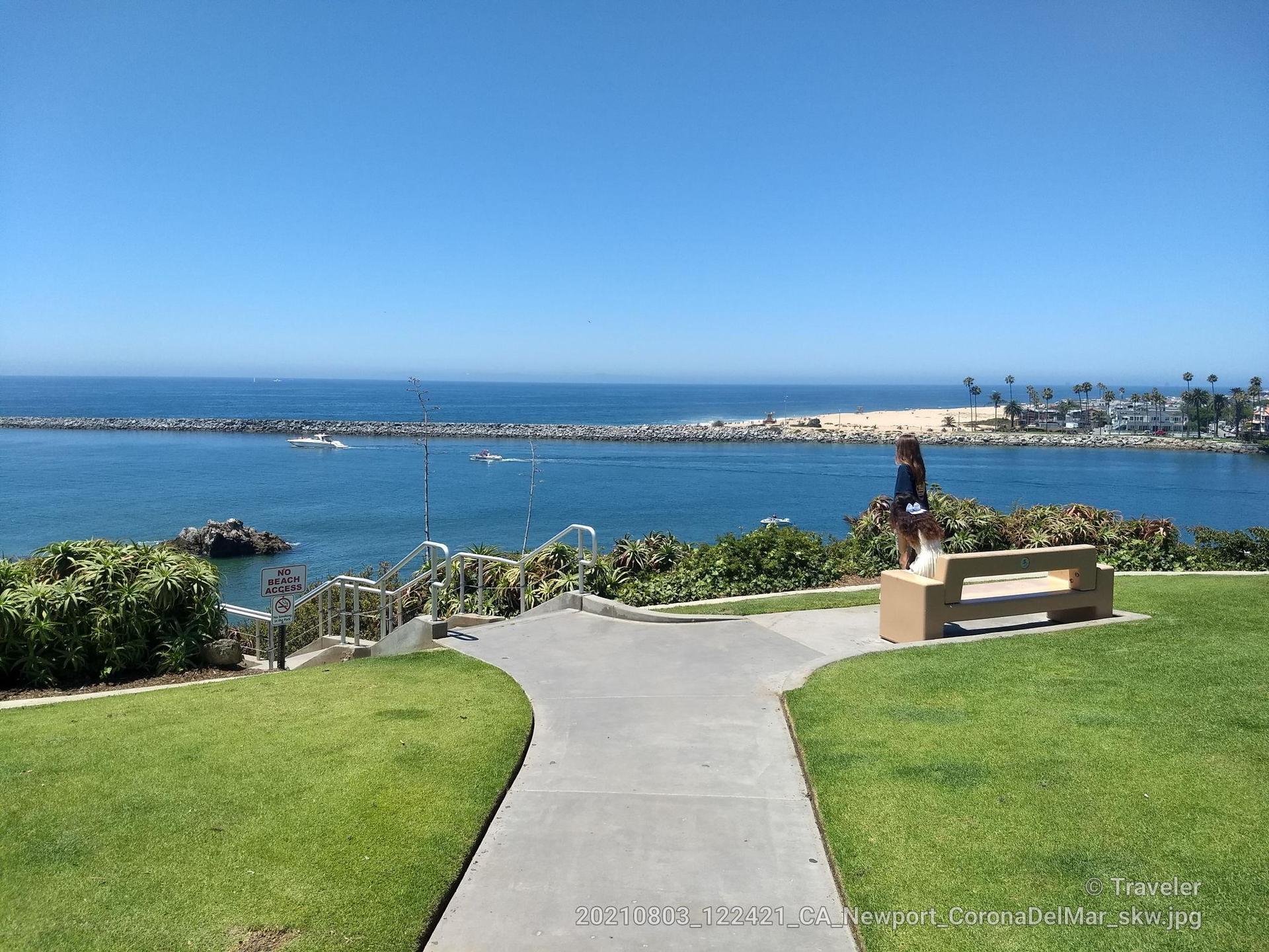 Scenic overlook with a bench and path, offering views of the ocean.
