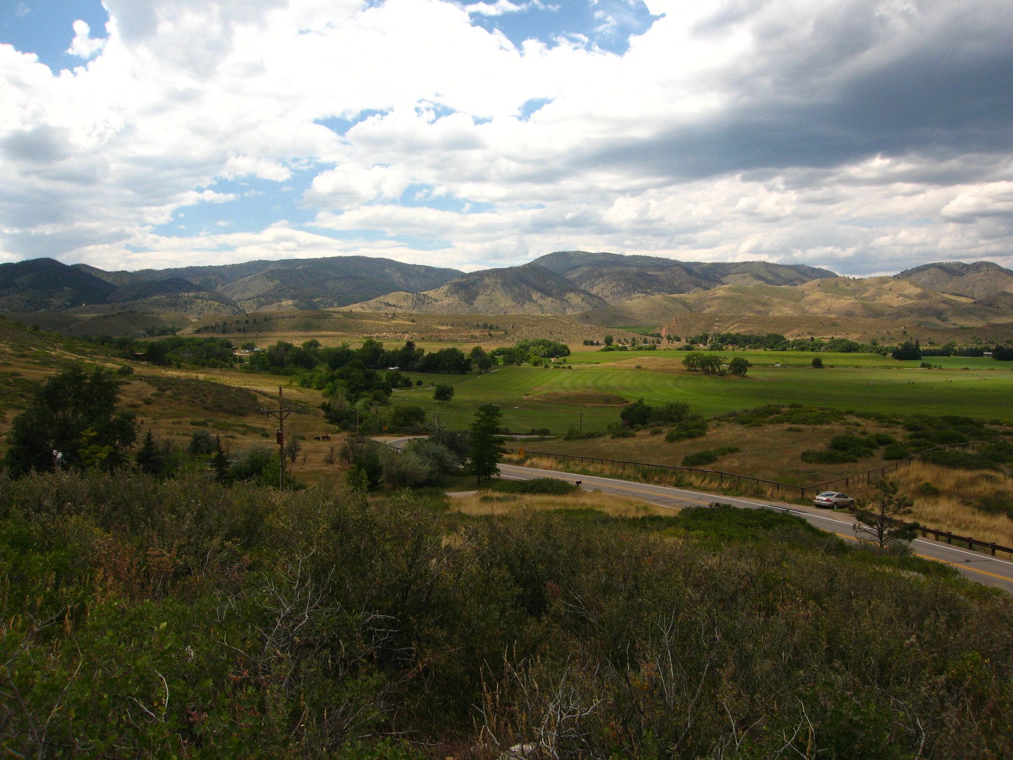 Expansive green valley with distant mountains under a cloudy sky. - Bingham Hill – Spring Canyon Park loop from Horestooth Overlook