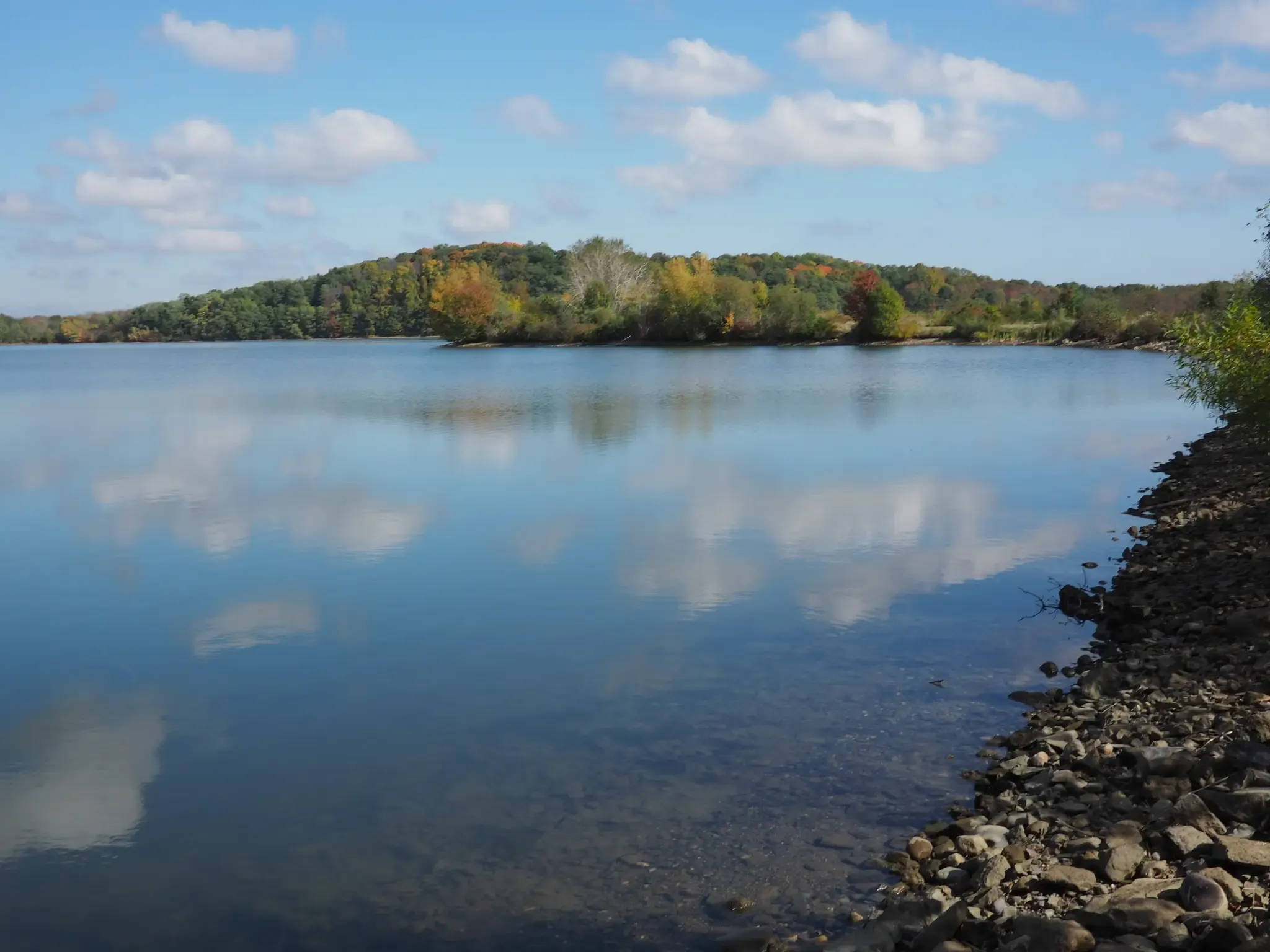 A calm lake reflecting blue sky and clouds, with forested hills. - Ornes Hill – Georgetown Rowley State Forest loop from Georgetown-Rowley State Forest