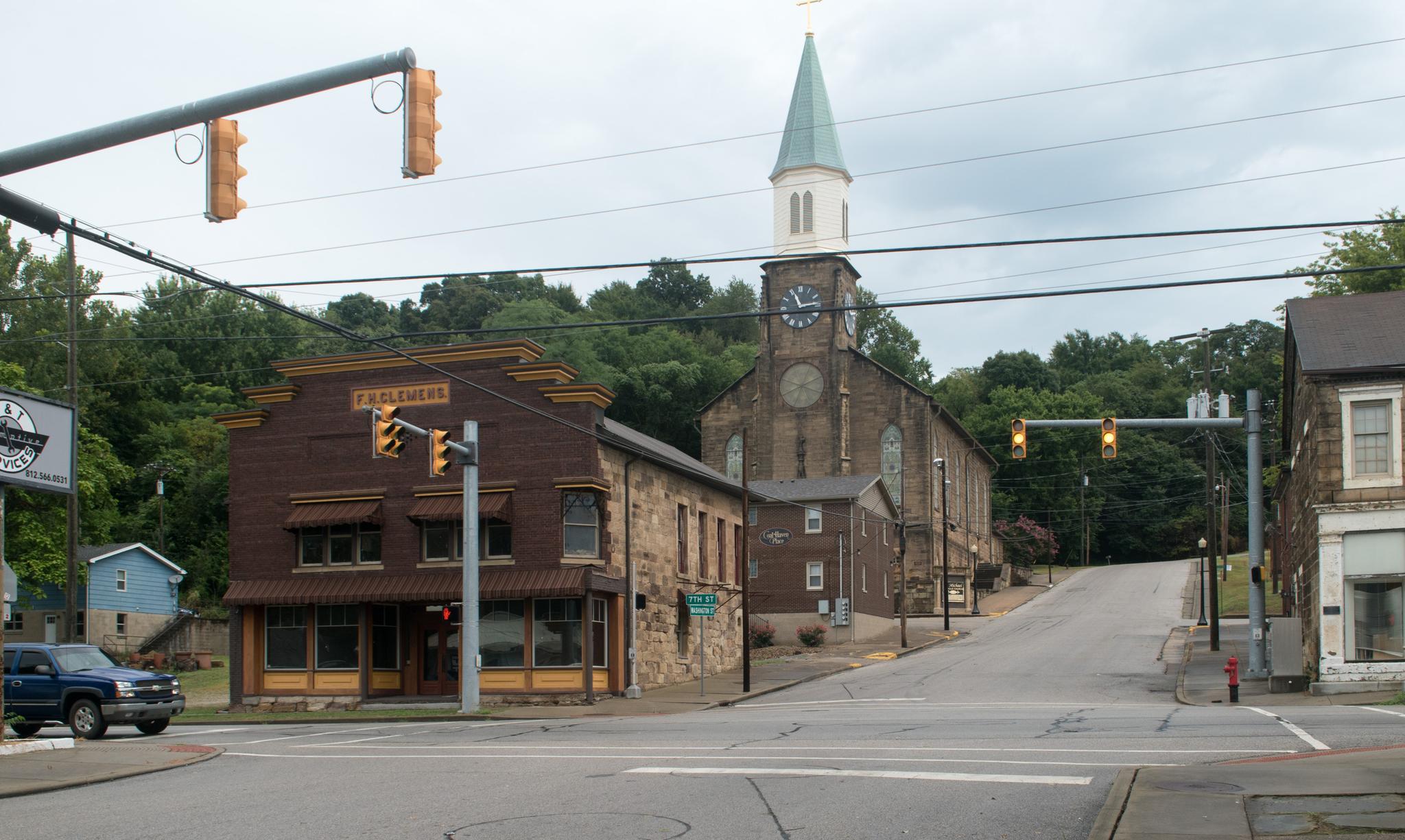 A street corner with historic buildings and a church under an overcast sky.