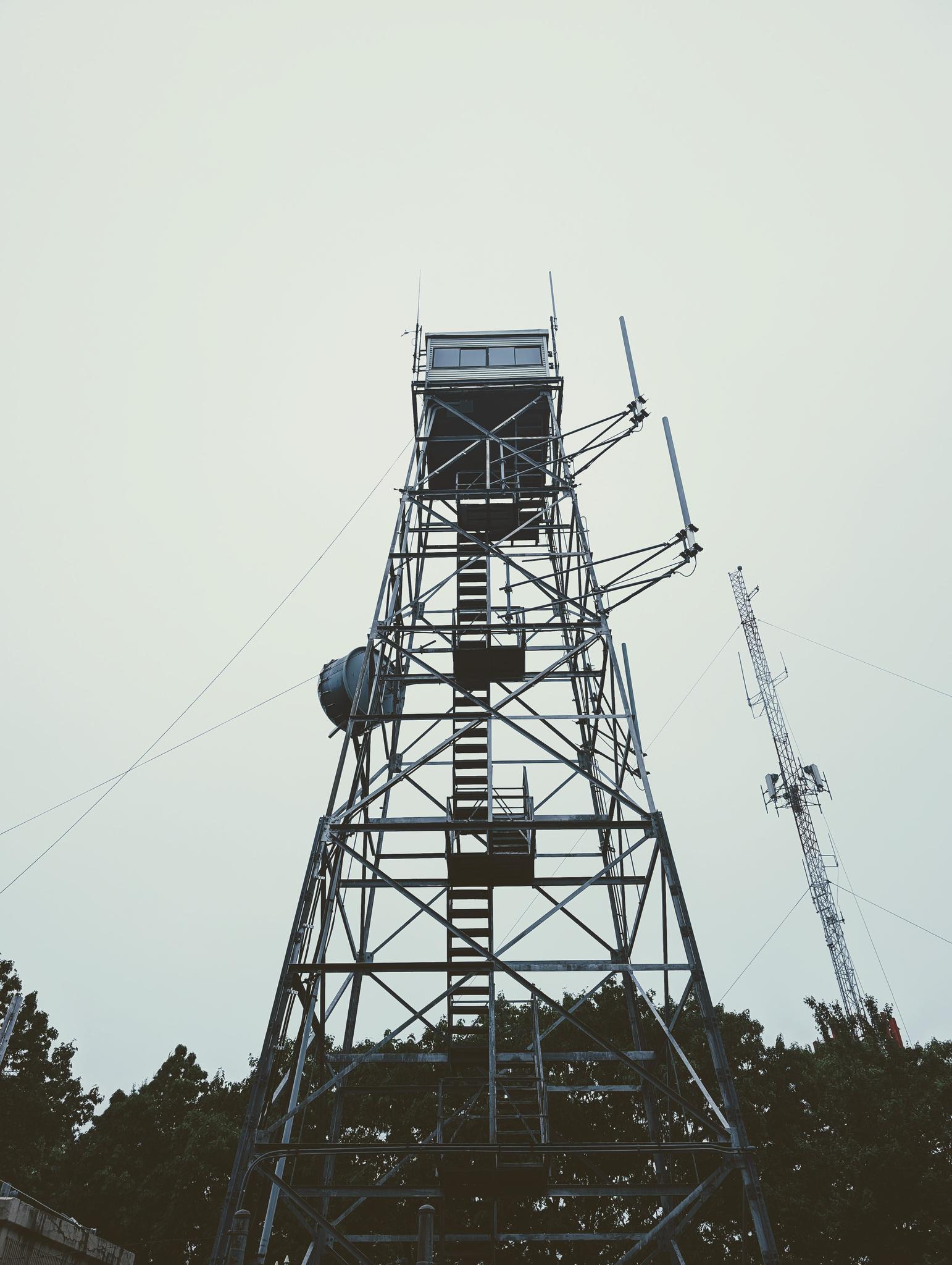 A tall metal observation tower stands against an overcast sky.