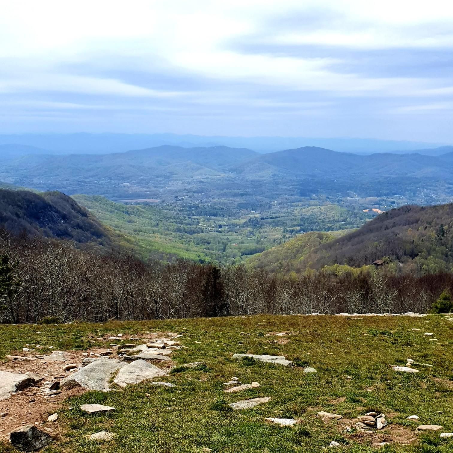 Overcast mountain vista with a green valley and rocky foreground. - Bearwallow Mountain Loop Trail