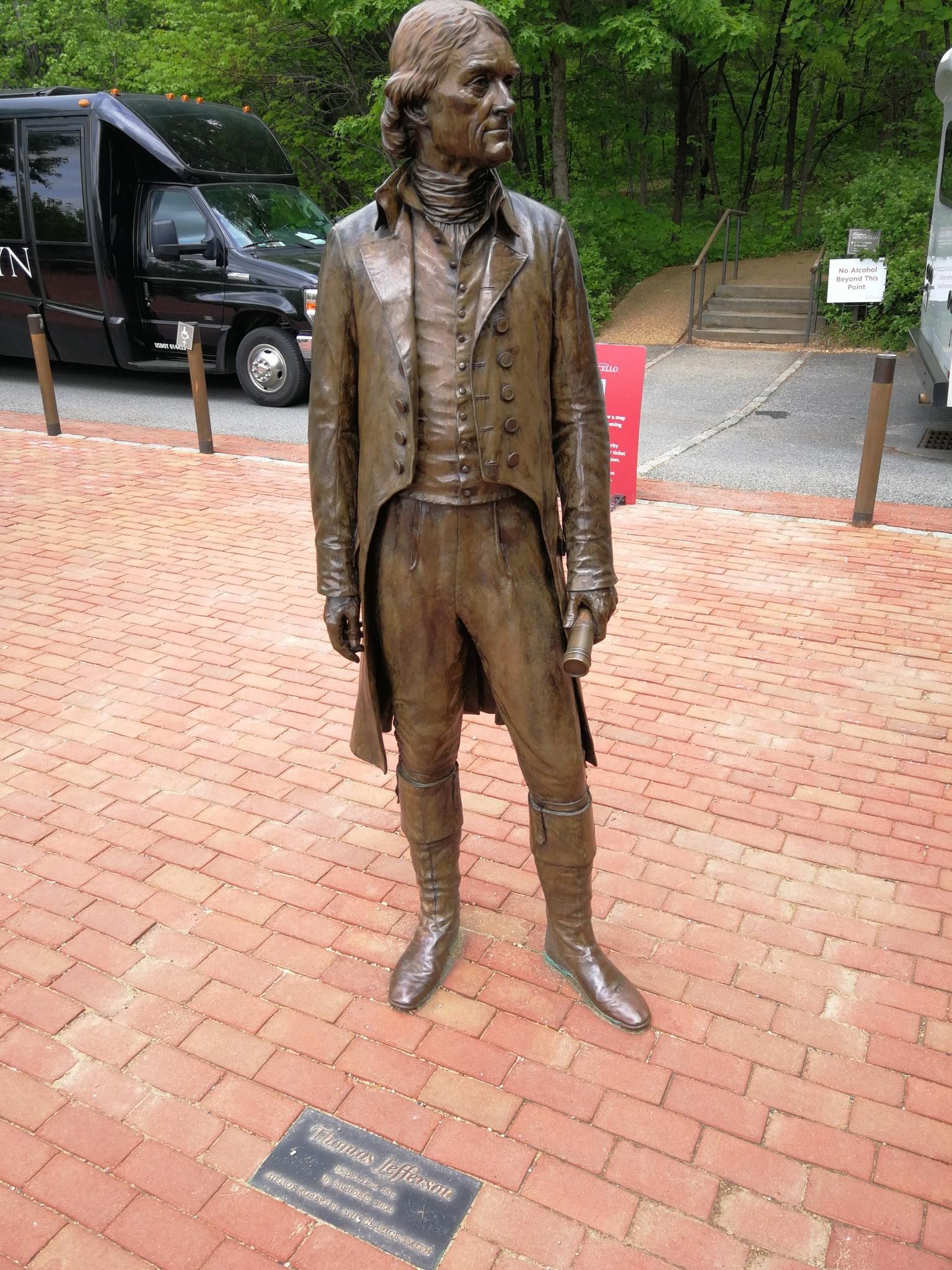 Bronze statue of a man in historical clothing on a brick path. - Saunders-Monticello Trail