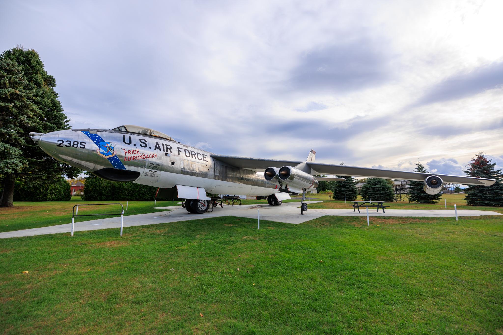 Large silver U.S. Air Force plane on display in a grassy field.