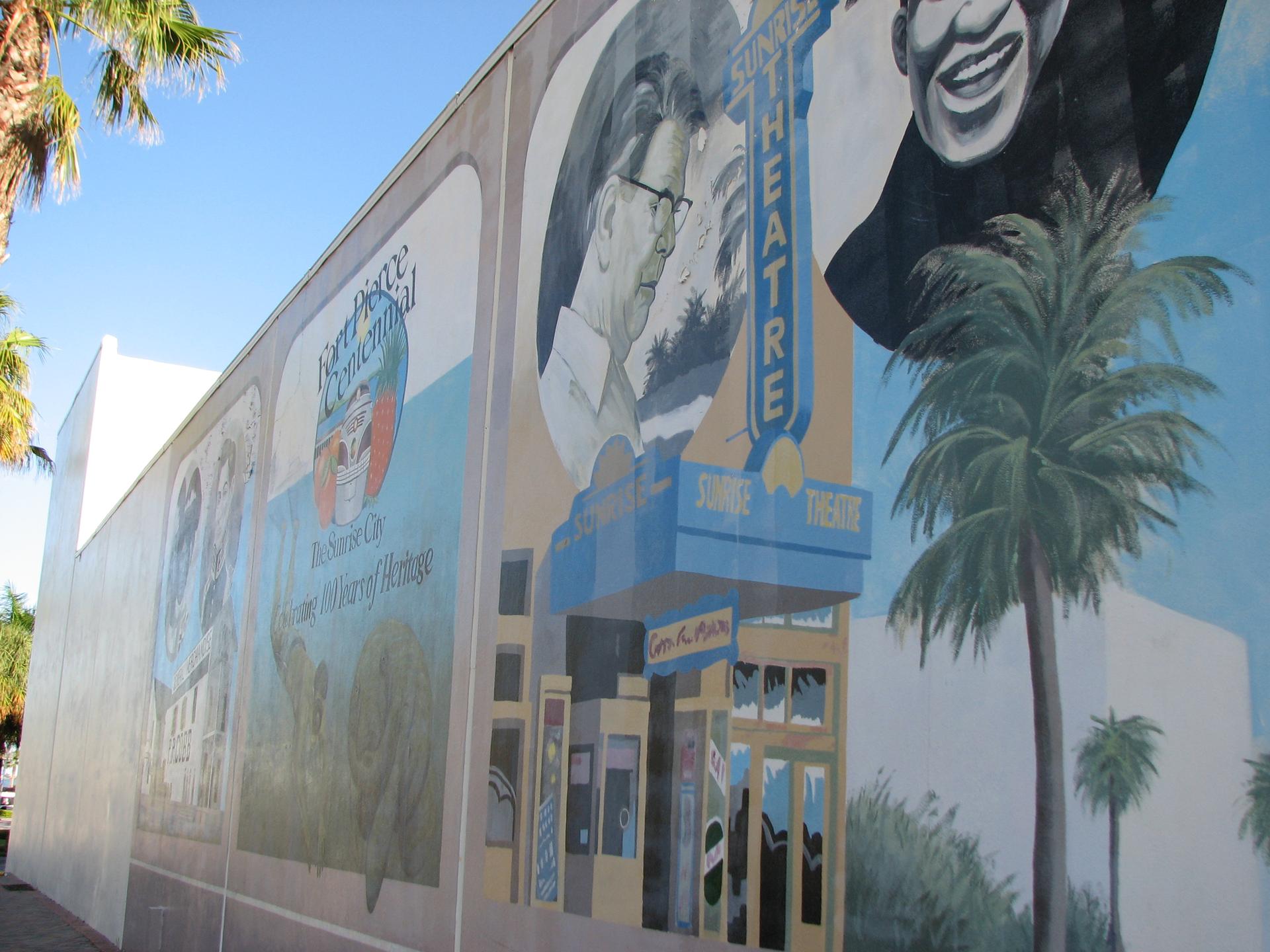 A vibrant outdoor mural on a building wall under bright daylight.
