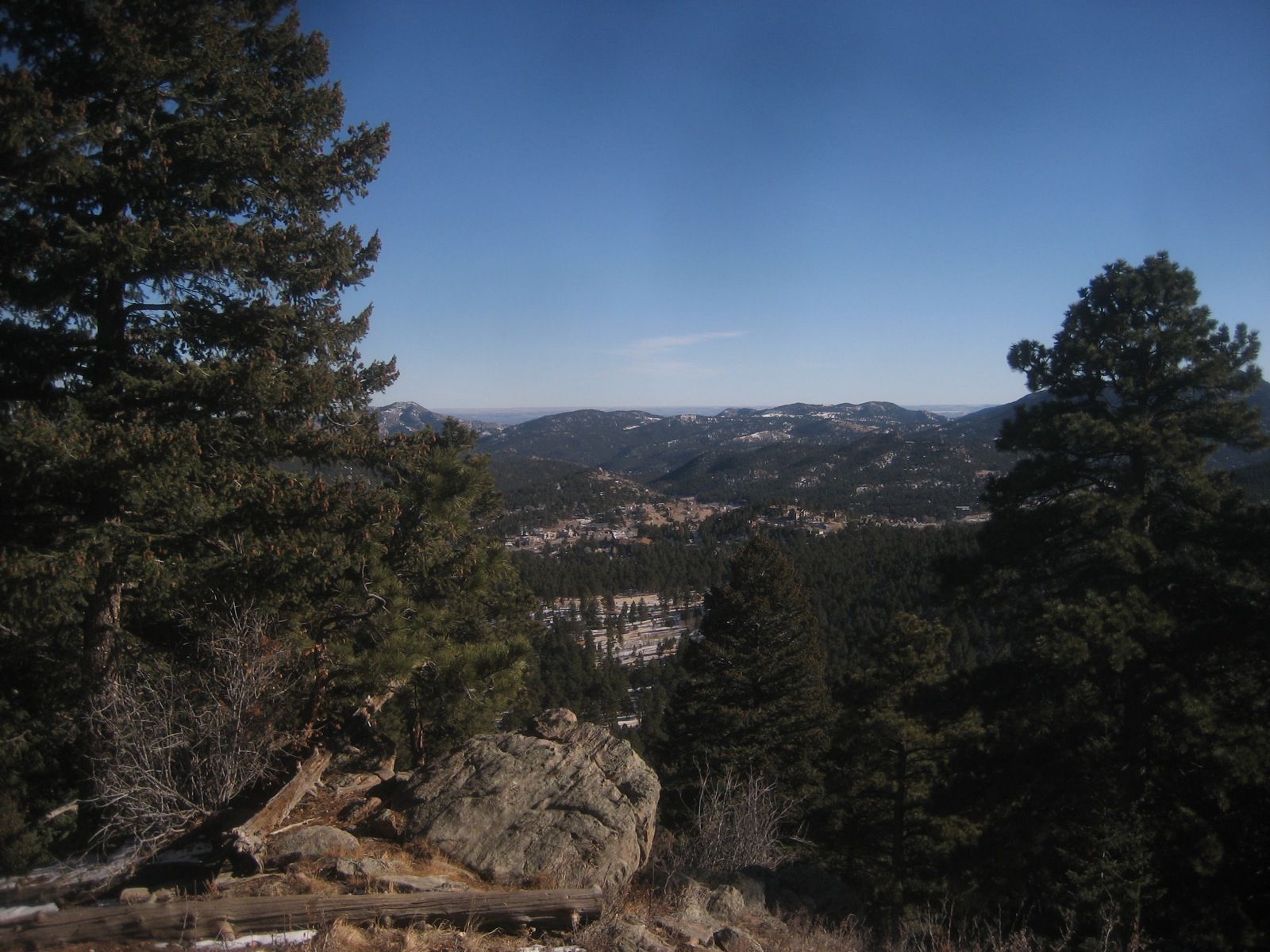 Evergreen trees frame a vast valley and snow-dusted mountains on a clear day. - Painter's Pause, Meadow View, and Sleepy S Trail Loop