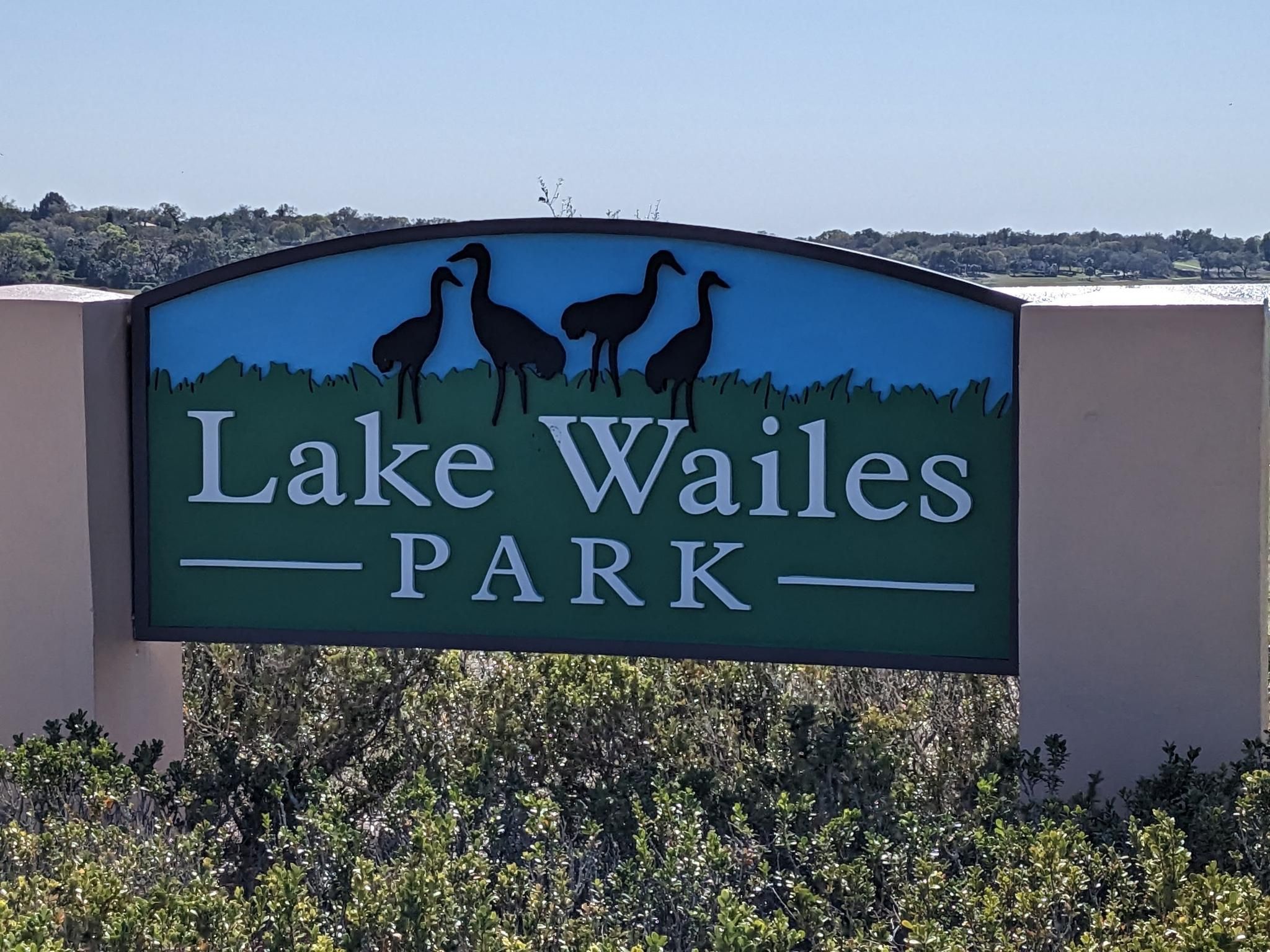 A park sign with bird silhouettes against a blue and green background. - Lake Wailes Trail