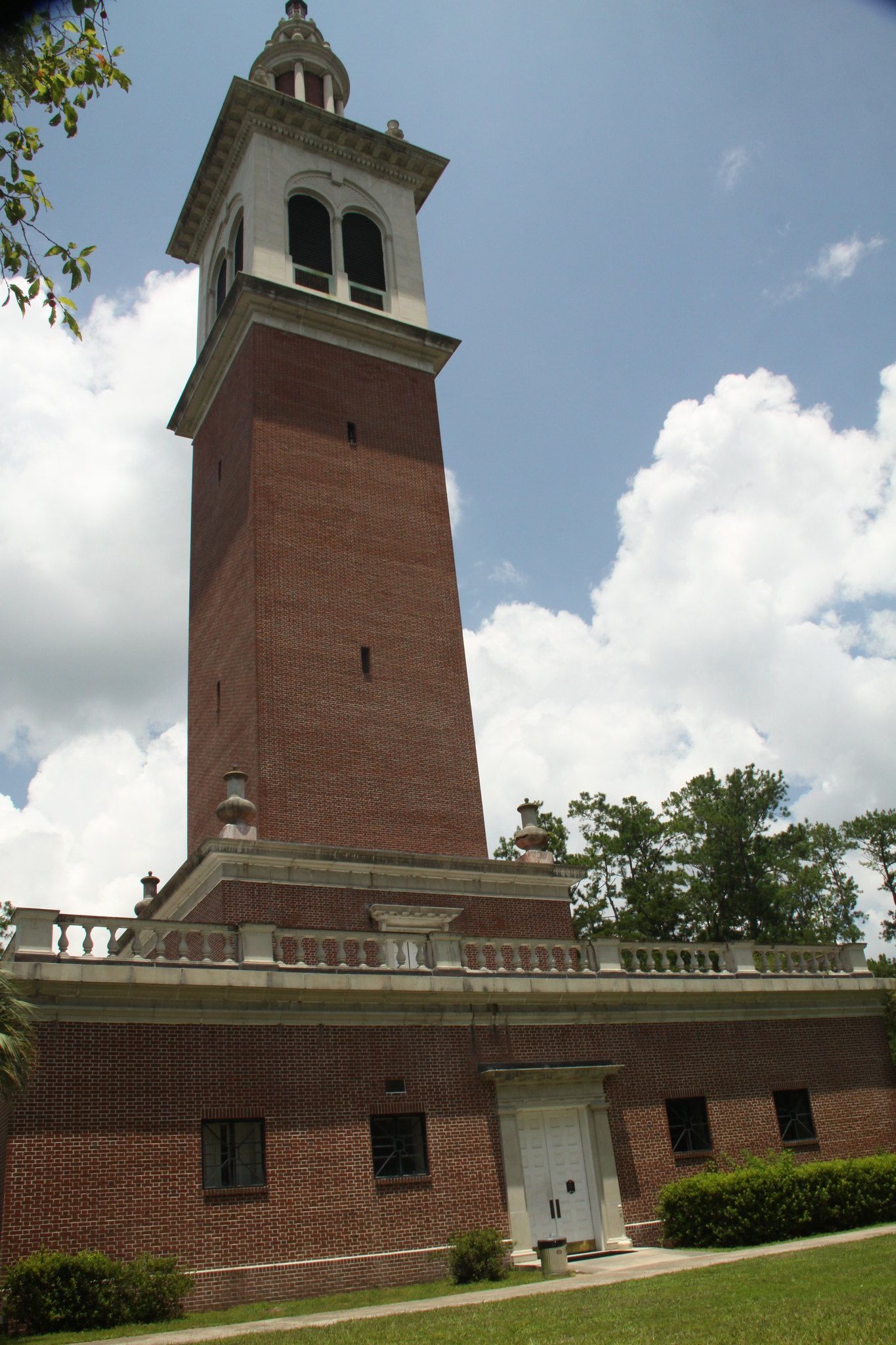 A tall brick tower with a white top against a cloudy blue sky. - Stephen Foster Folk Culture Center State Park Loop