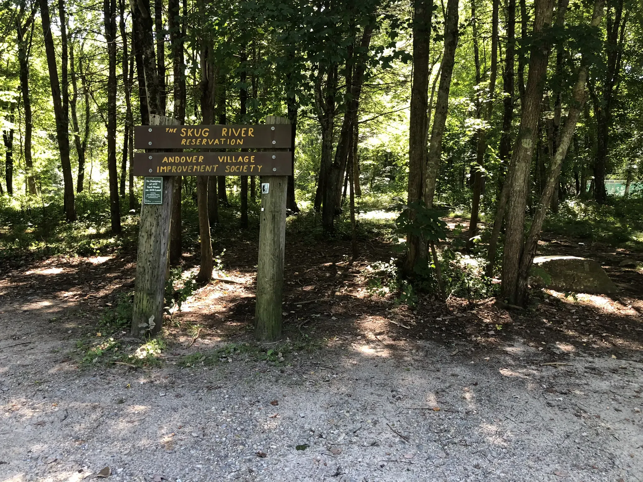 Two wooden signs on posts at a sunlit forest path entrance. - Skug River Reservation – Field Pond loop from Andover