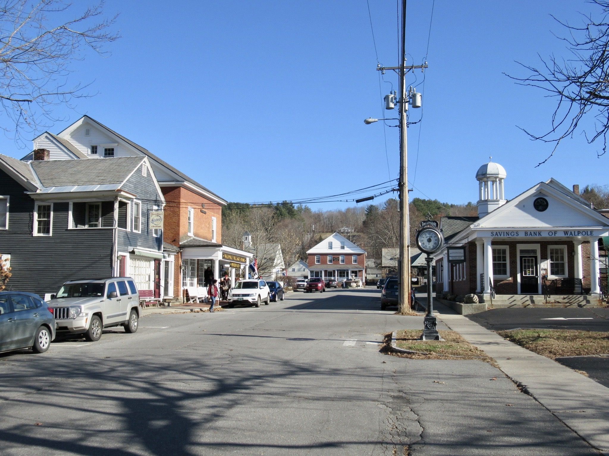 Sunny street scene with historic buildings, parked cars, and people walking. - Walpole – Hooper Hill loop from Great Brook Town Forest