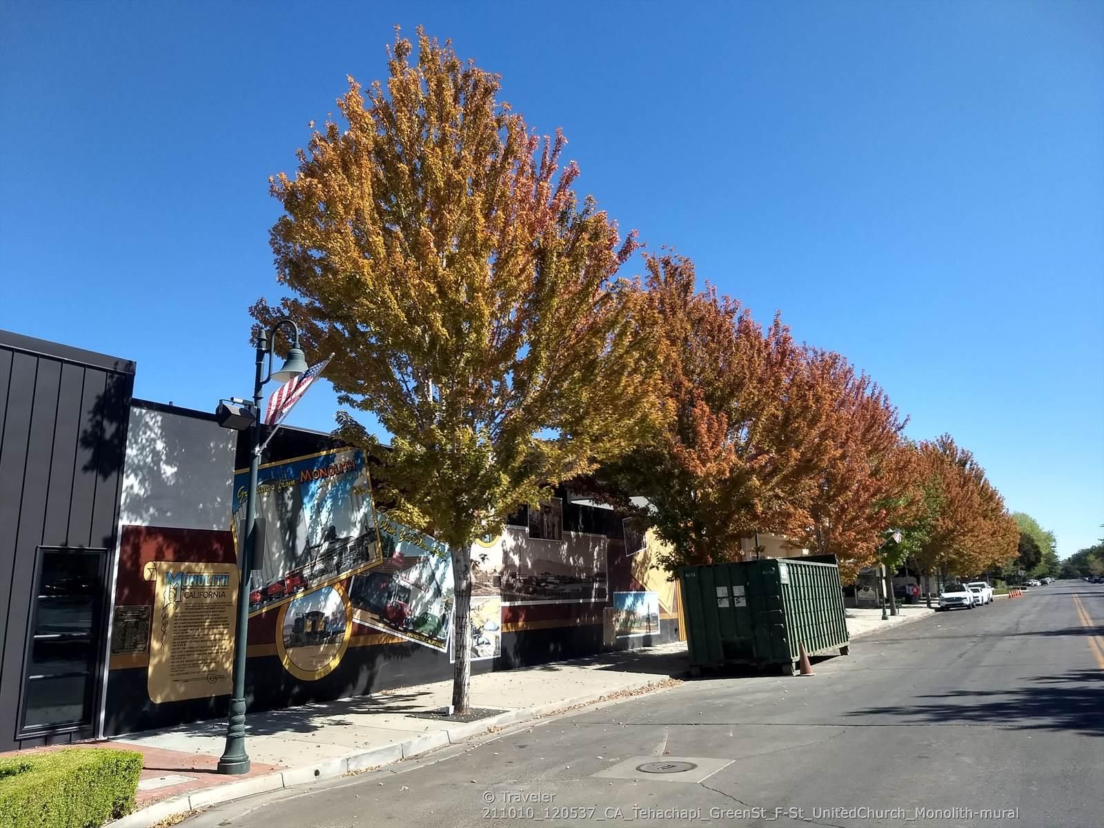 Urban street with autumn trees, a building mural, and clear blue sky. - Bakersfield to Tehachapi loop