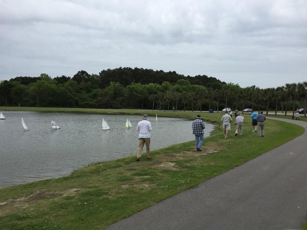 People operate remote control sailboats on a lake under an overcast sky. - James Island County Dog Park – James Island County Park loop from James Island
