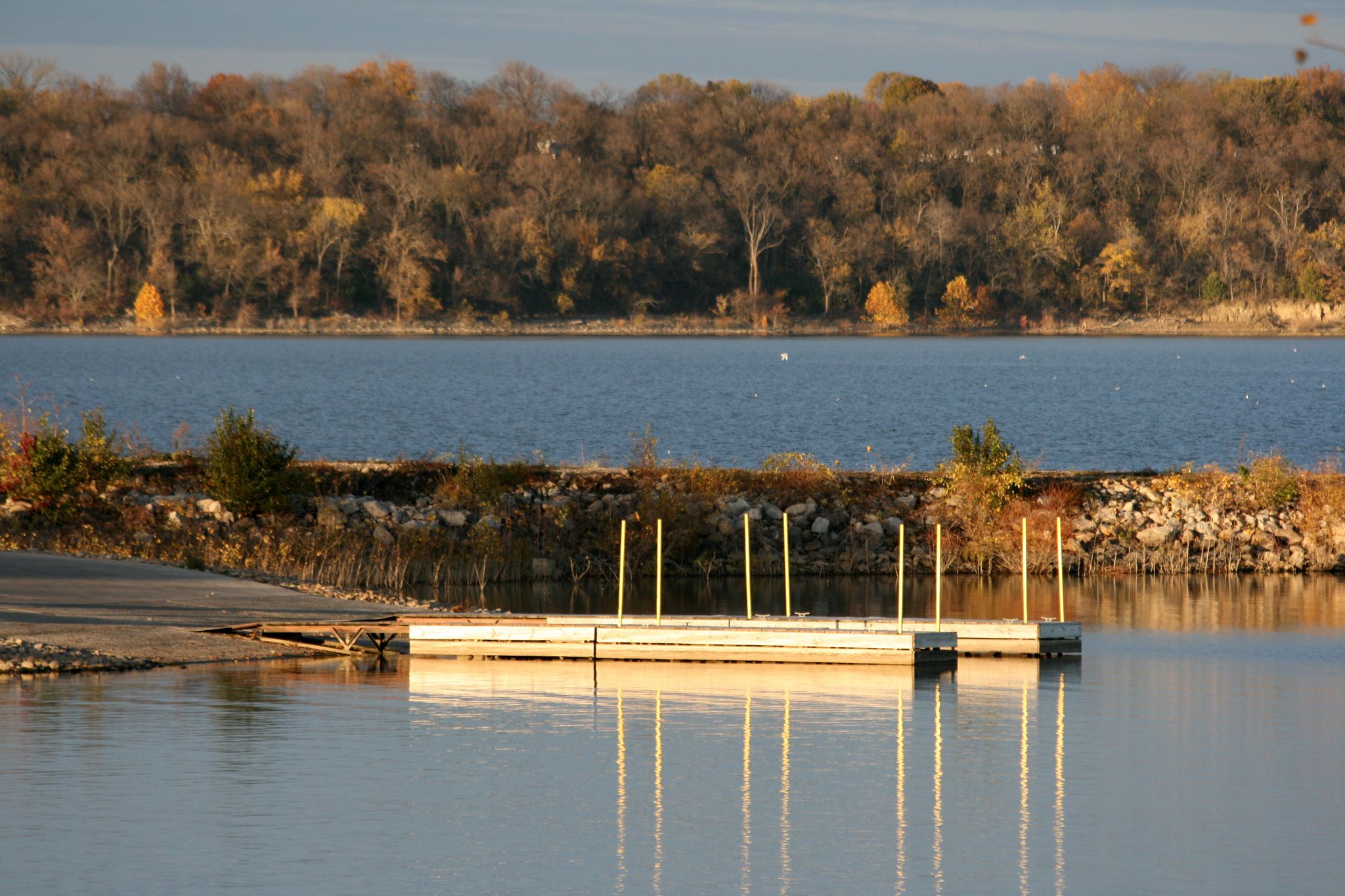 Floating dock on a lake with autumn trees under warm golden light. - Lawrence to Clinton State Park loop — Douglas County