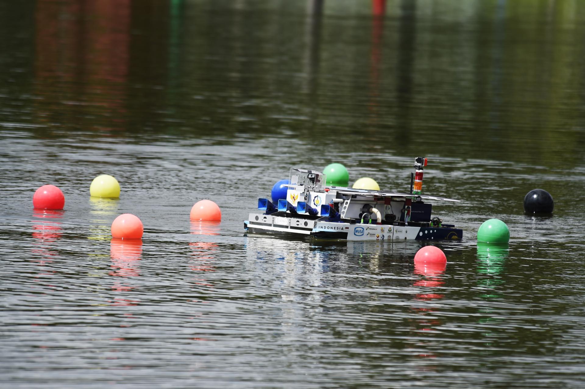 A small boat floats on calm water, surrounded by colorful buoys.