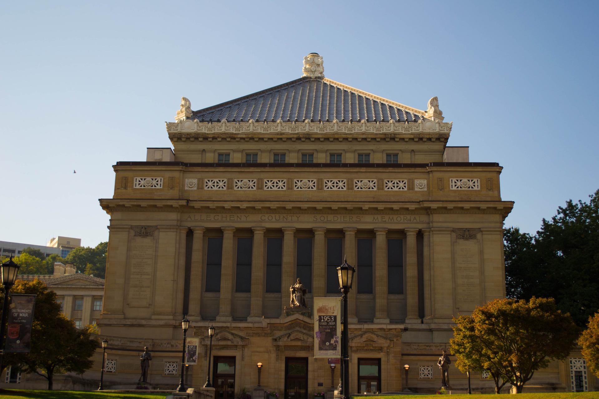 Ornate building with columns and tiled roof under a clear blue sky.
