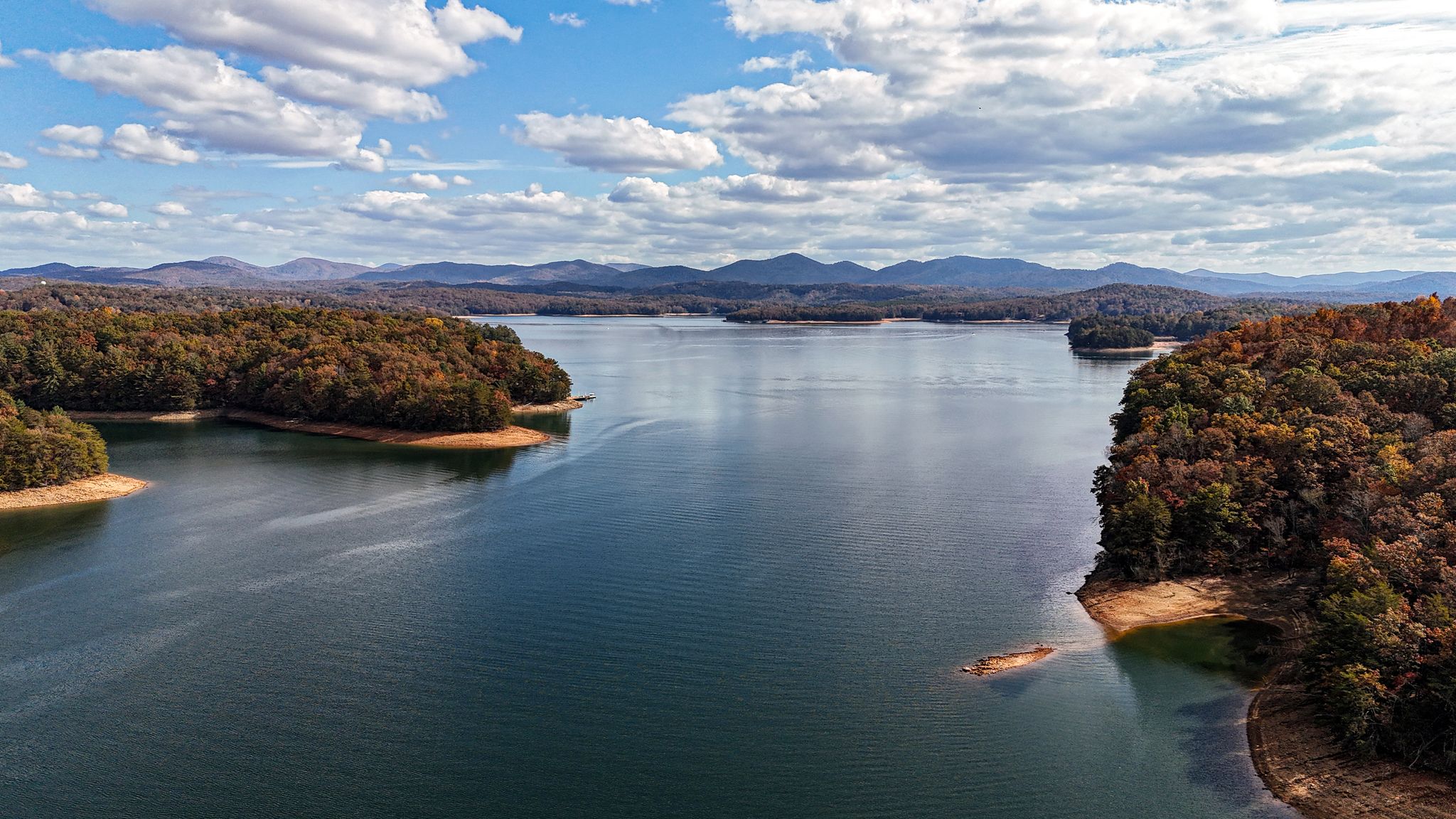 Aerial view of a large lake surrounded by autumn forested hills. - Blue Ridge Dam to Aska Road loop