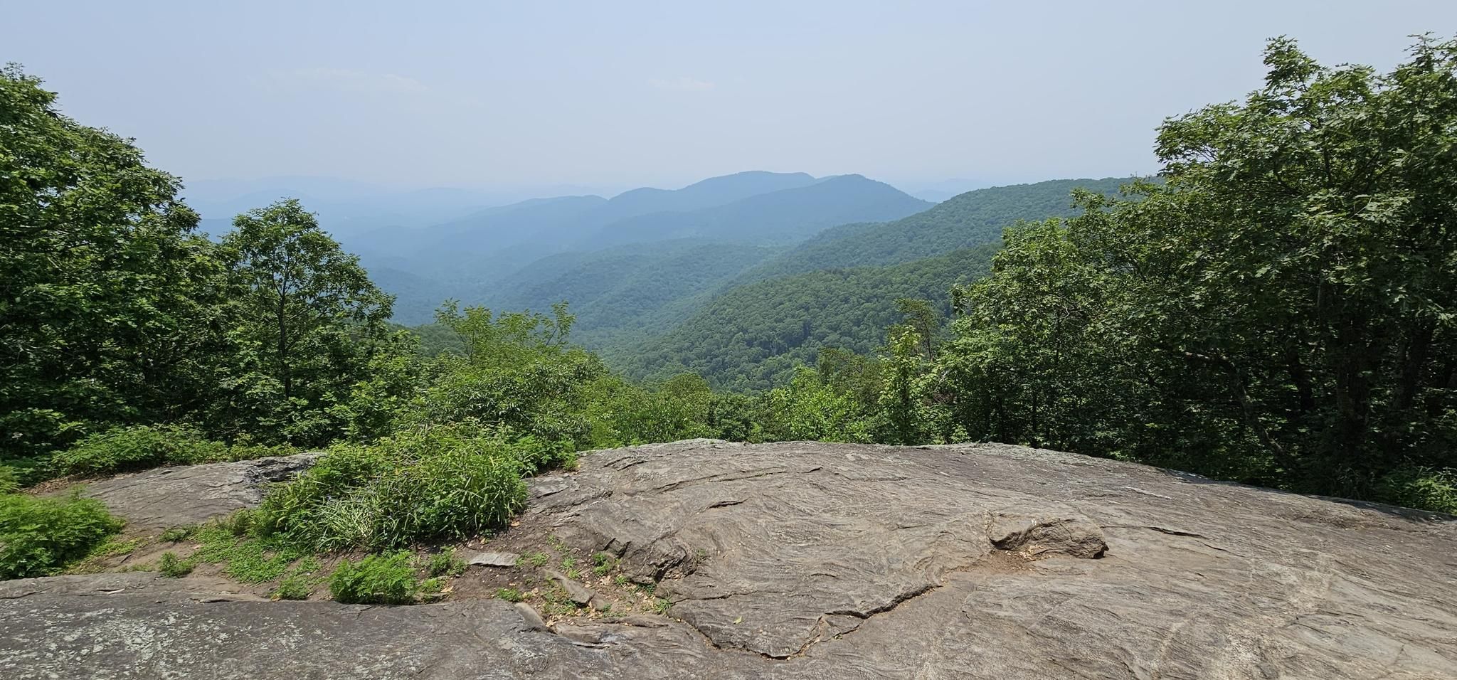 Hazy, forested mountain range viewed from a rocky overlook under an overcast sky. - Appalachian Trail to Preachers Rock