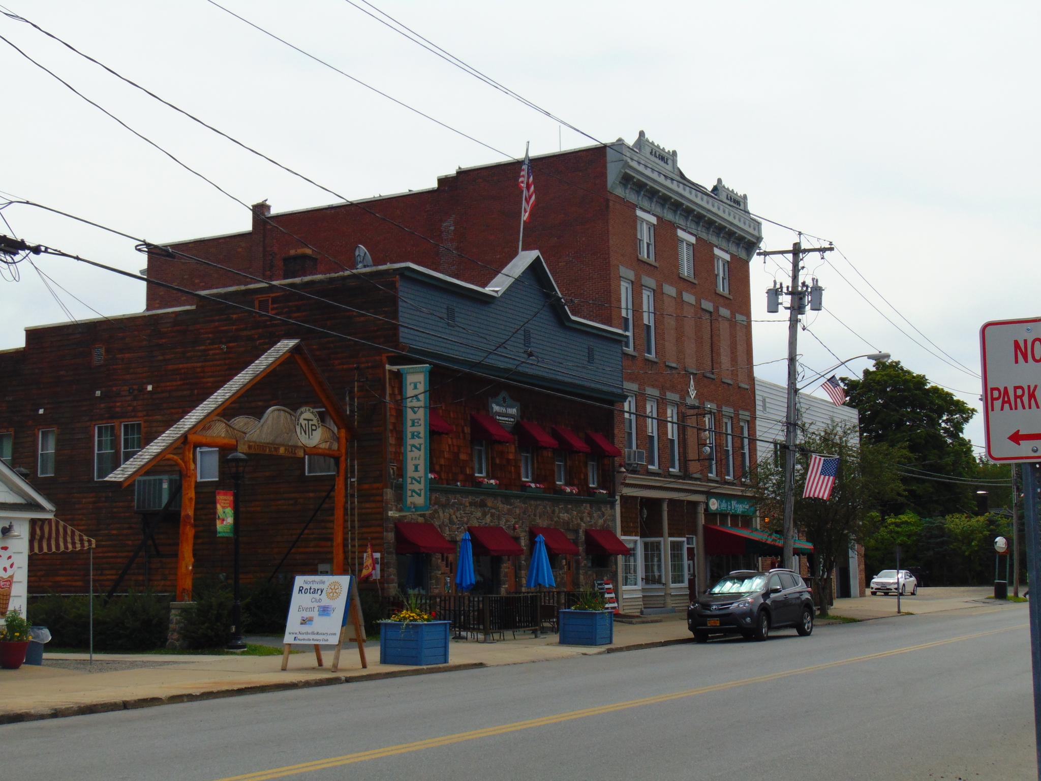 Quaint street with historic brick buildings and power lines on an overcast day.