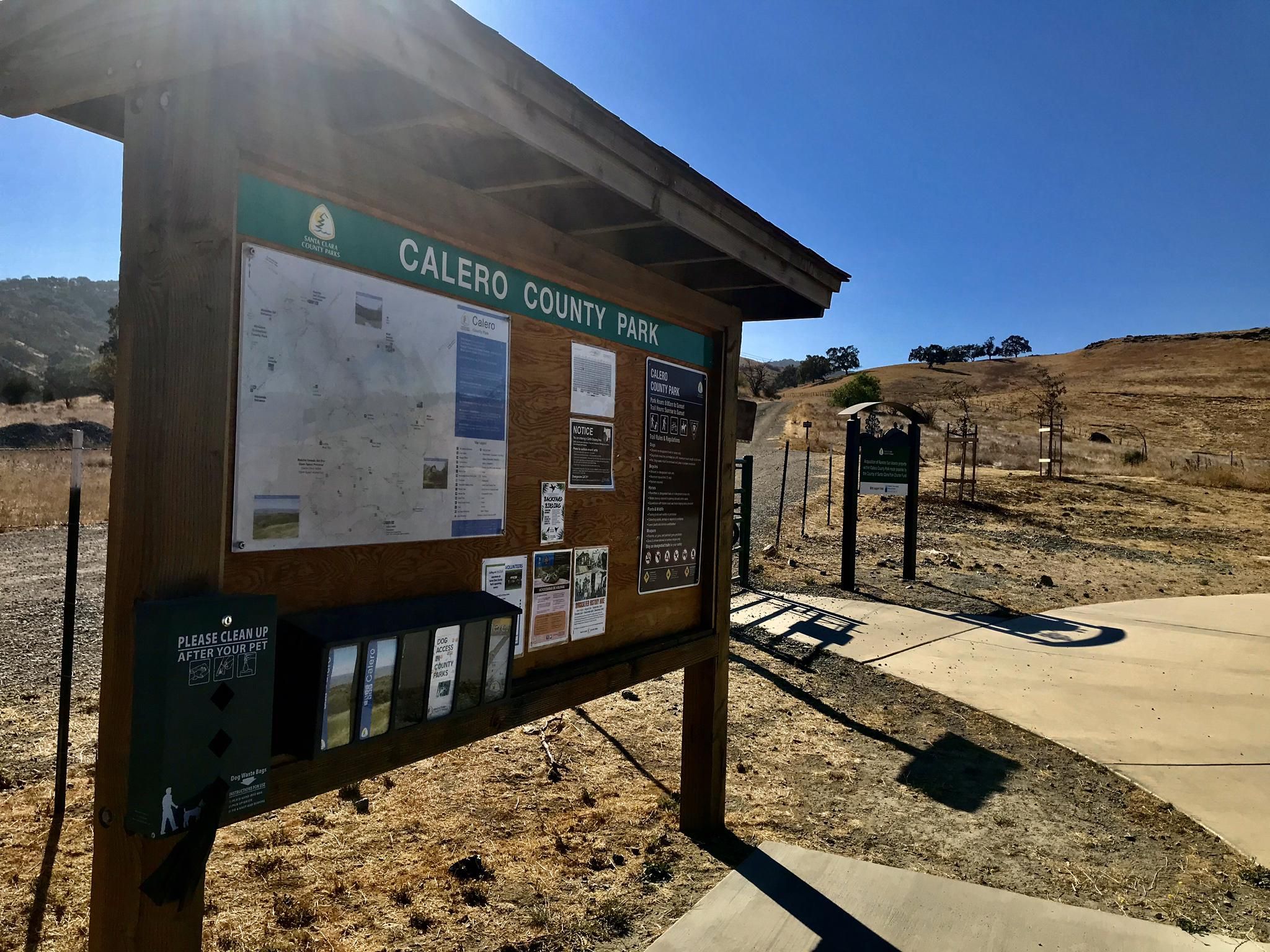 A wooden information board stands on a sunny, dry, hilly landscape. - Rancho San Vicente Trailhead loop from Rancho San Vicente Entrance