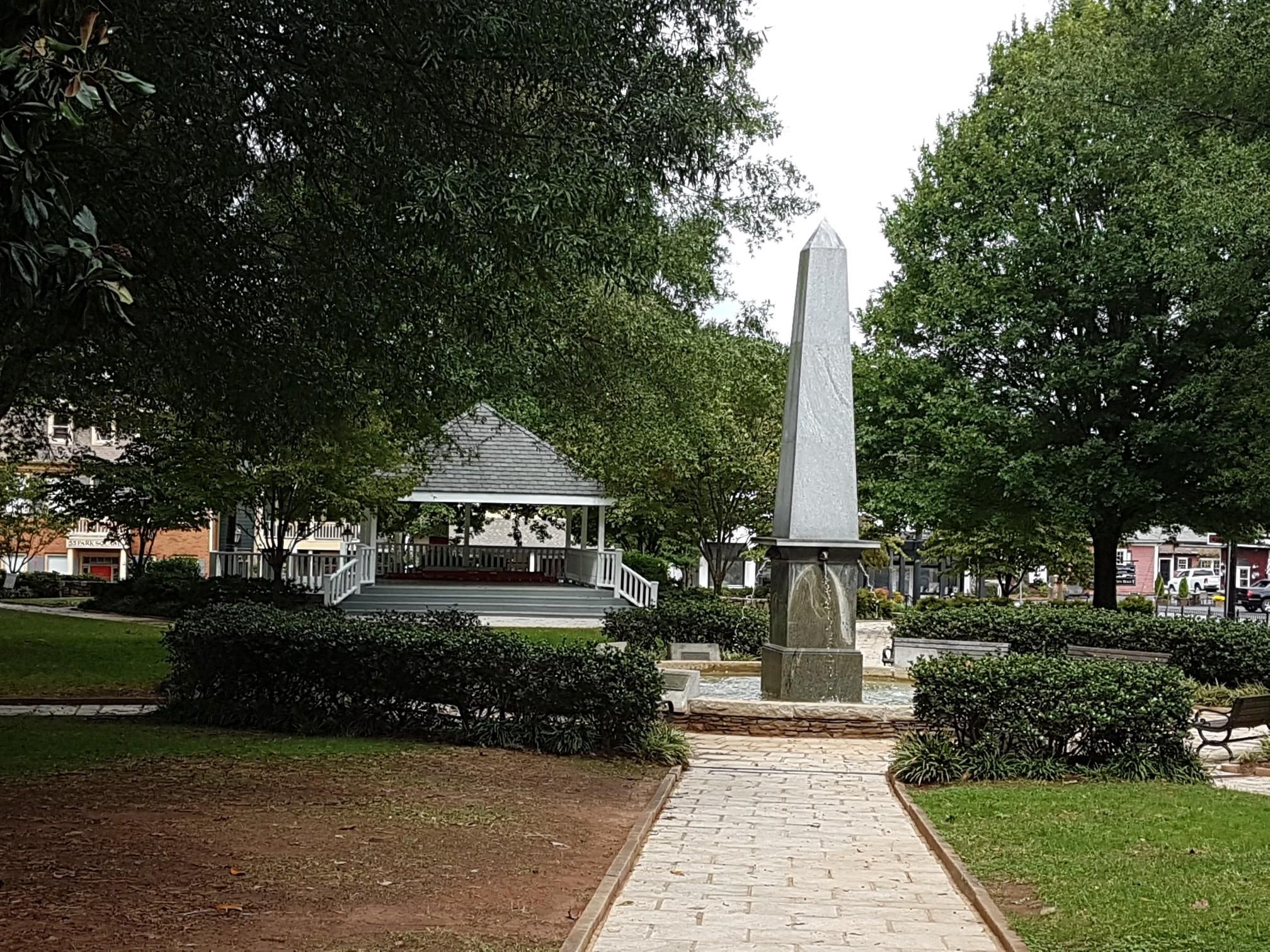 A park scene with a tall obelisk, white gazebo, and green trees. - Lower Roswell and Roswell Riverwalk Trail Loop