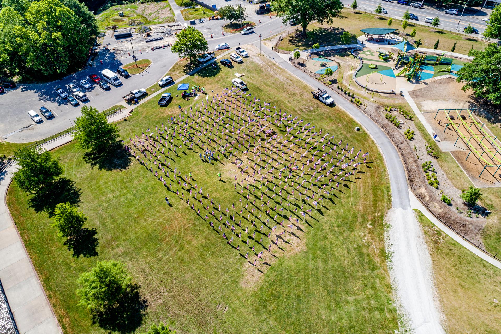 Aerial view of a large field with rows of flags under bright daylight.