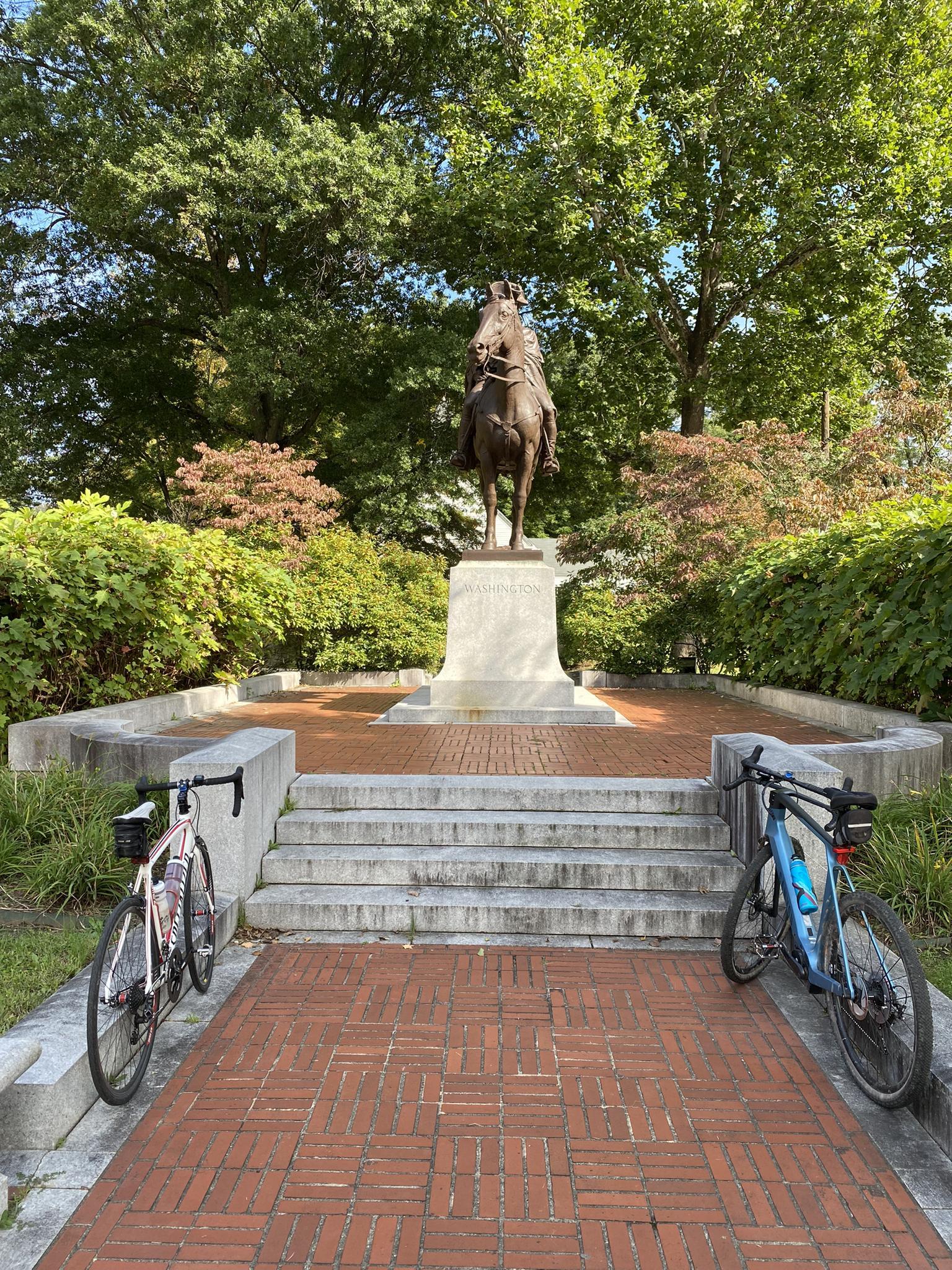 Equestrian statue on a stone pedestal, flanked by two parked bicycles.