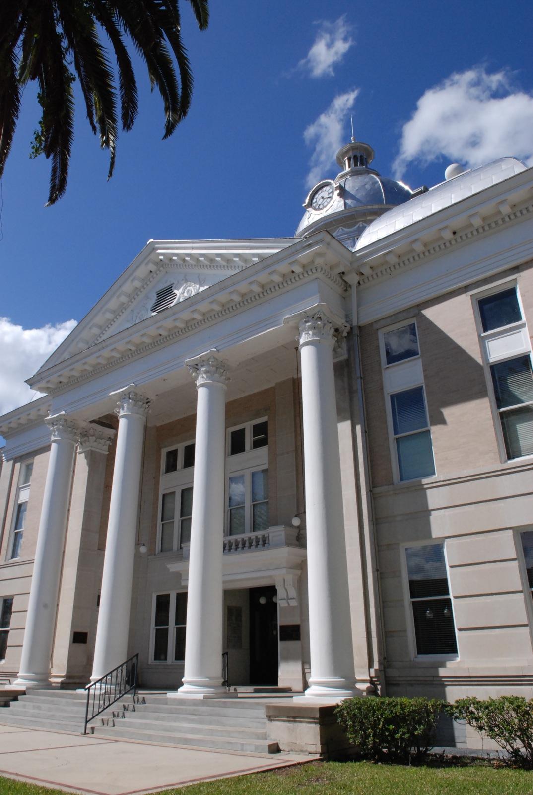 A grand, classical building with large columns and a dome under a blue sky.