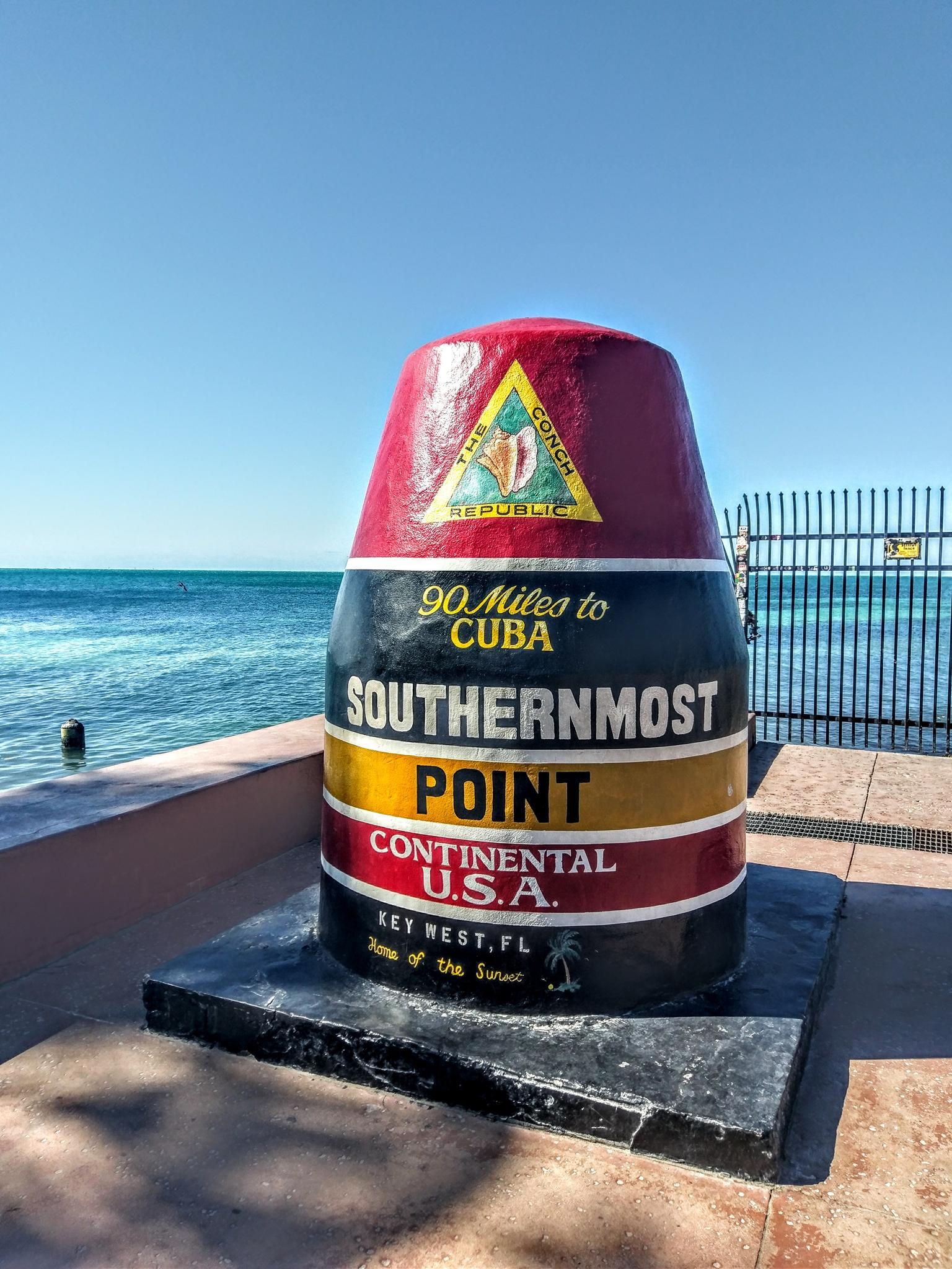 Colorful monument by the ocean under a bright blue sky.