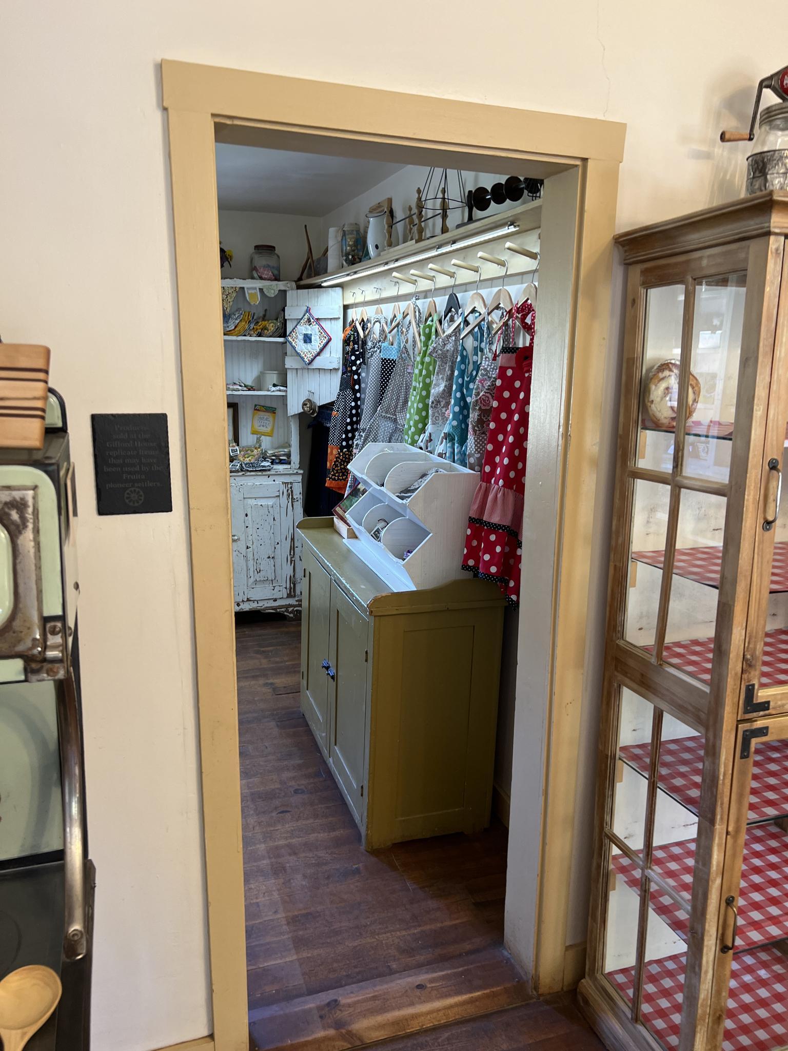 Interior view of a room with shelves, clothes on hangers, and furniture.