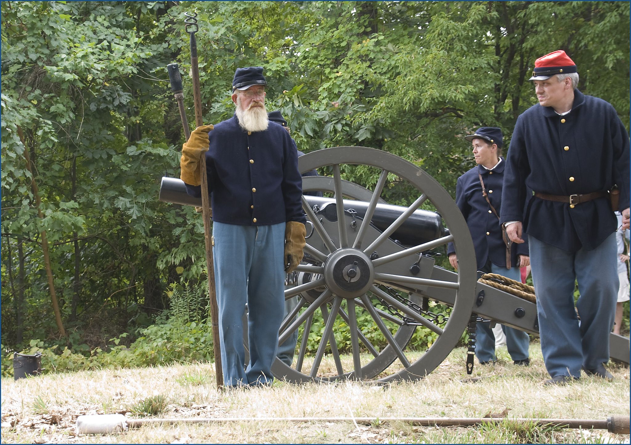 Three men in historical uniforms standing near a large cannon outdoors. - East Market at Fair Lakes – Ox Hill Battlefield Park loop from Fair Oaks