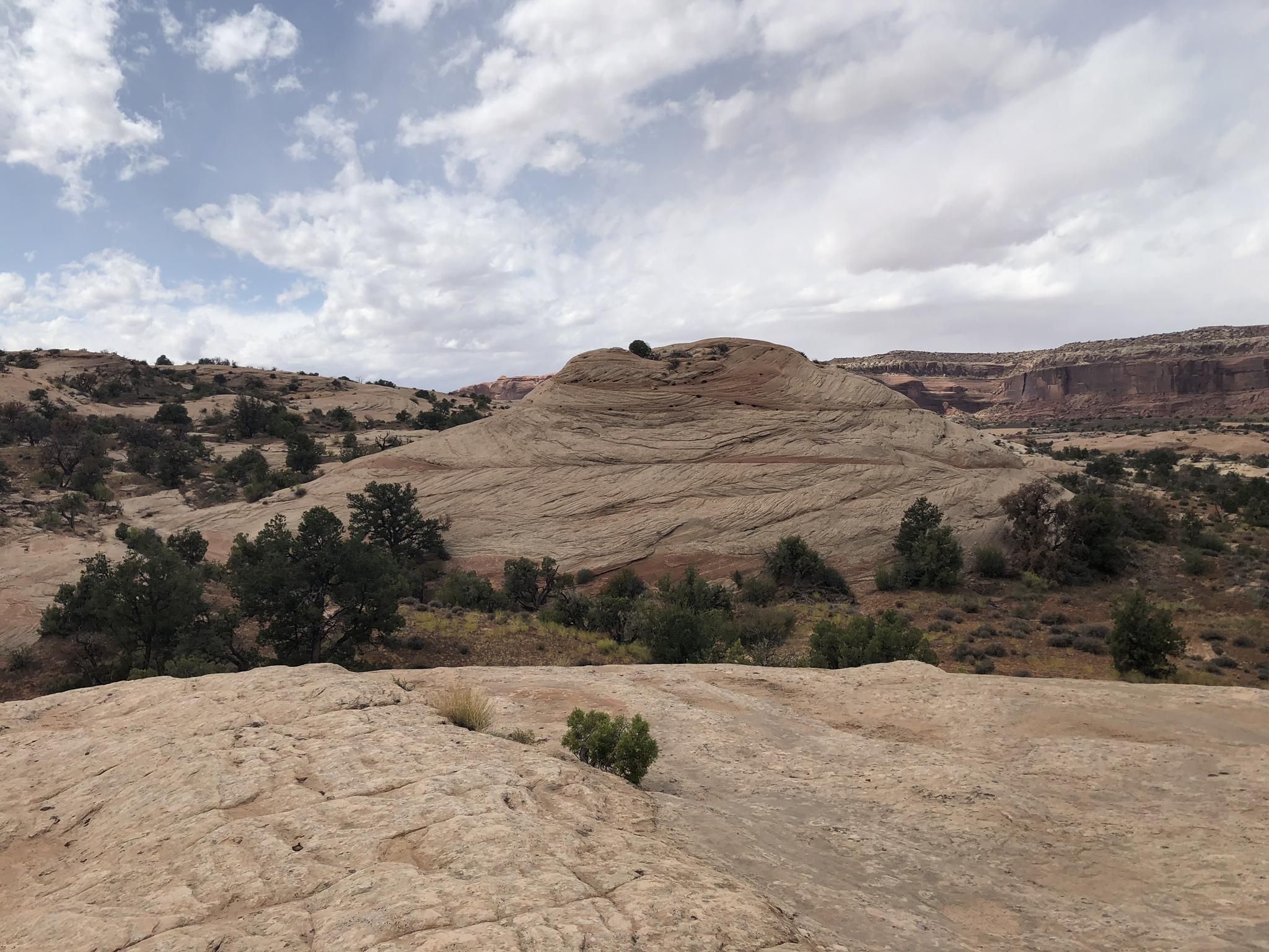 Rounded rock formation dominates a rocky desert landscape under a partly cloudy sky. - Rocky Tops and Ramblin' Loop