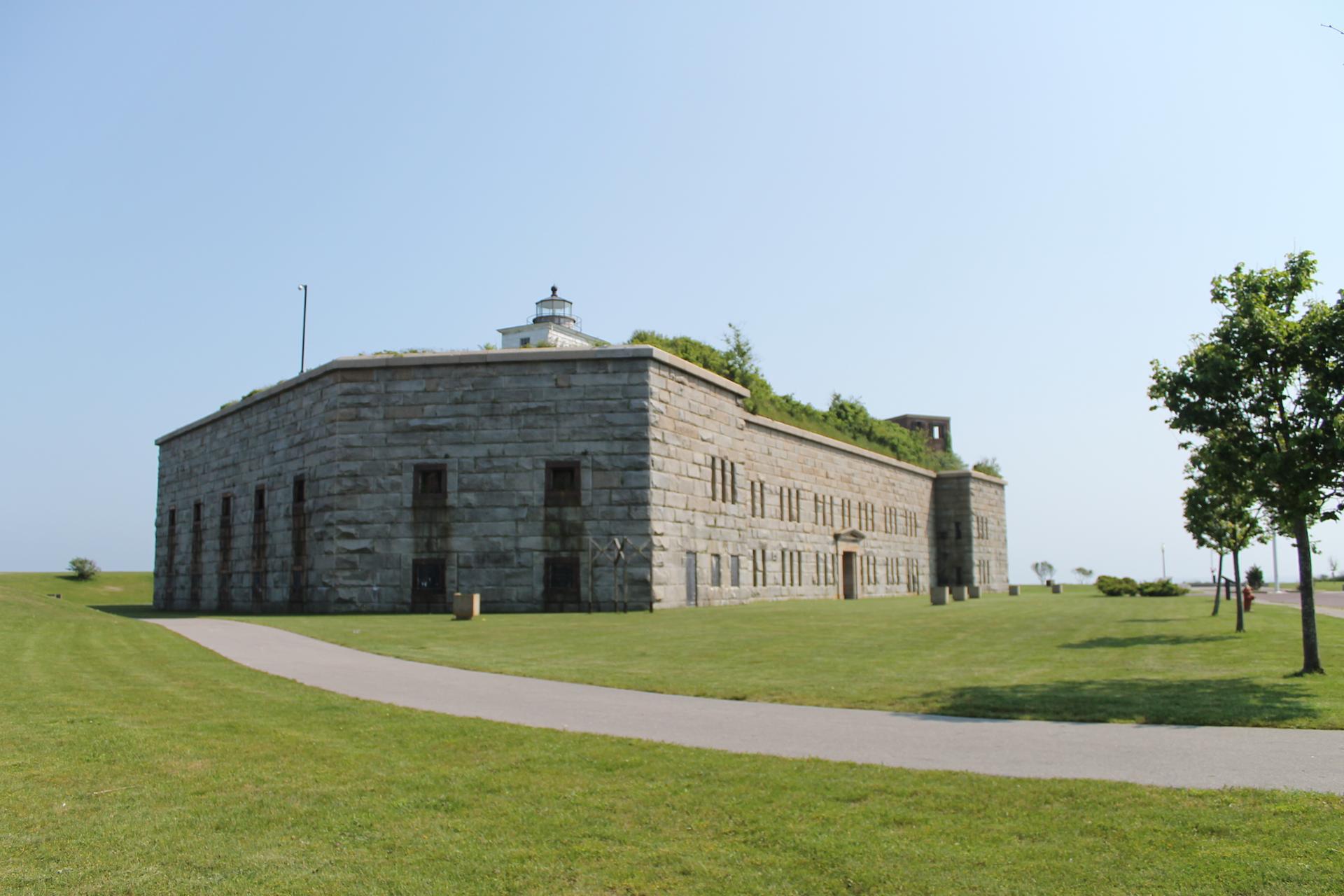 A large stone building with a lighthouse on top under a clear sky.