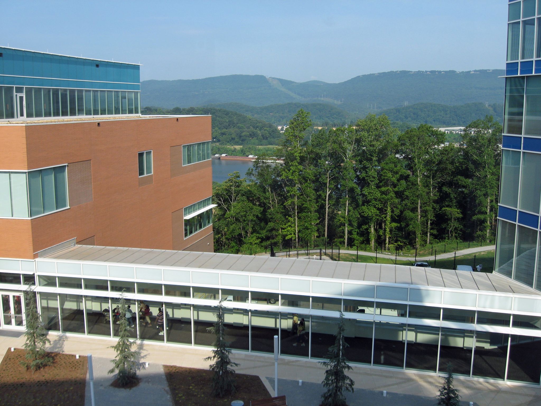 Modern buildings overlooking a lake and distant green mountains on a clear day. - Chattanooga loop via Cameron Hill
