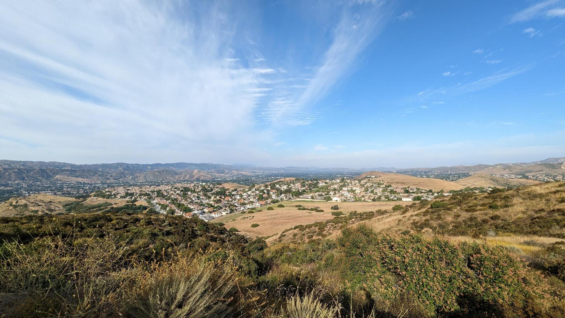Panoramic view of a town nestled in a valley surrounded by hills.