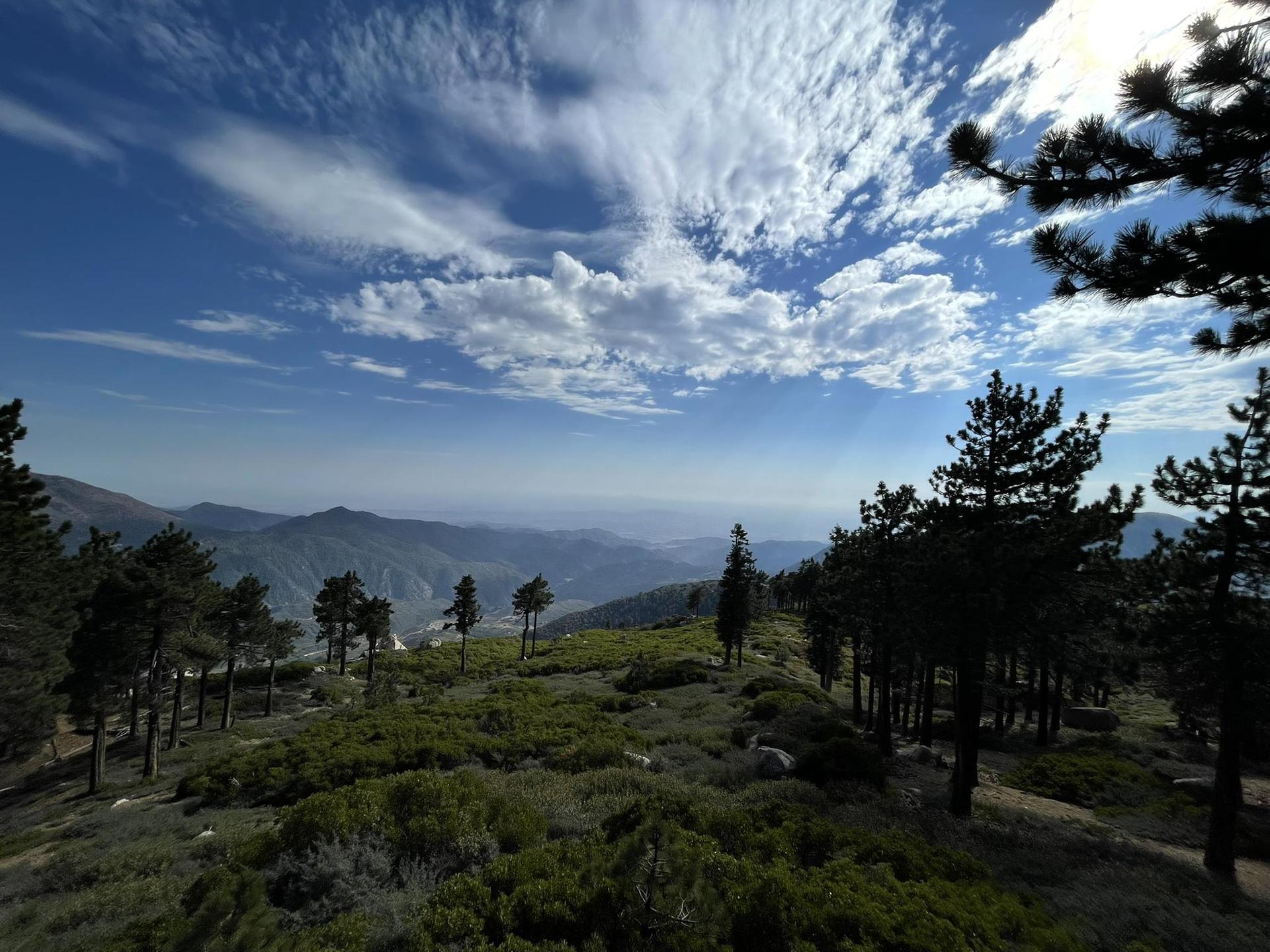 Panoramic view of a vast mountain range under a partly cloudy sky.