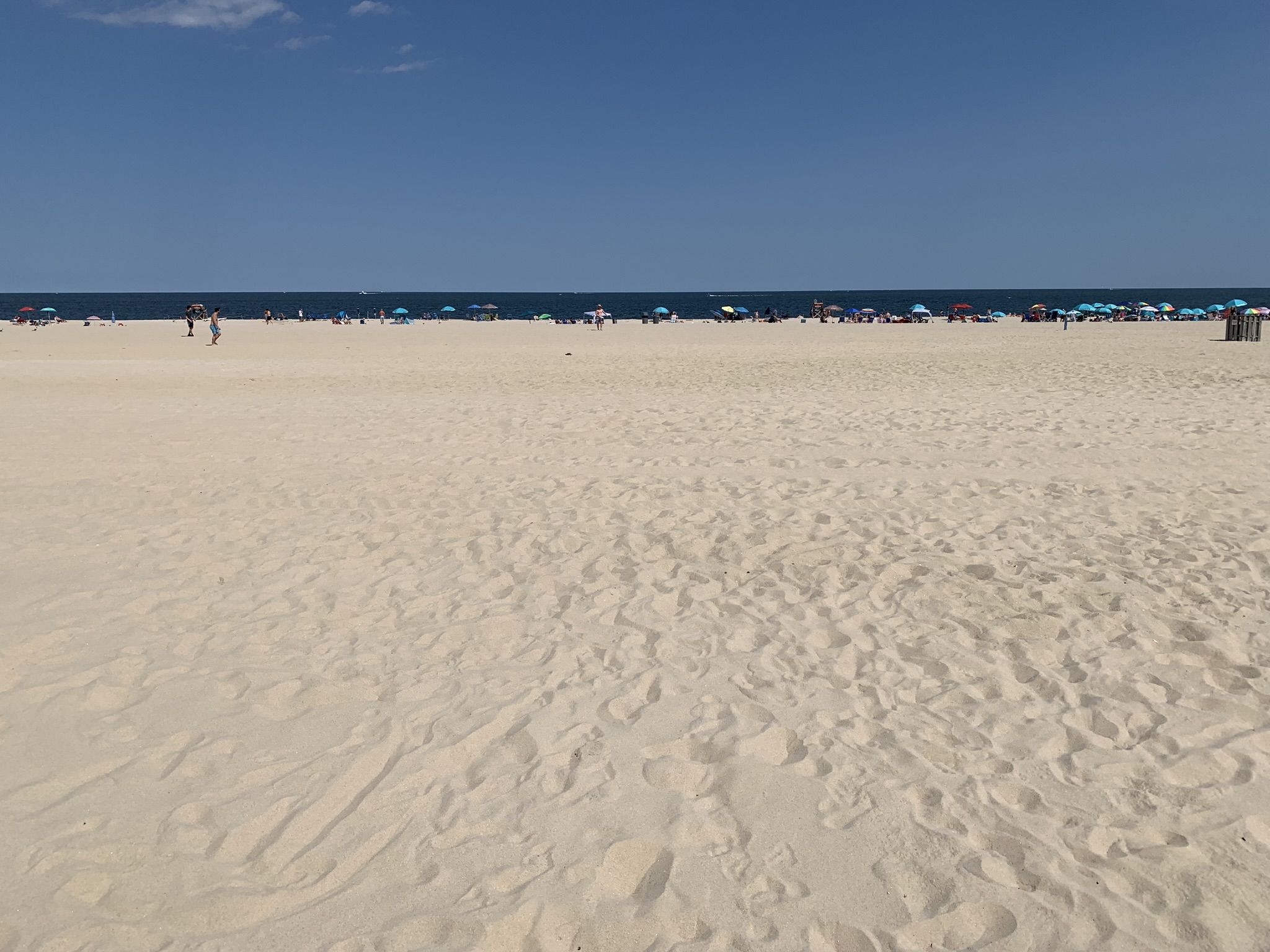 Wide sandy beach under bright sun, with distant people and umbrellas by the ocean. - Point Pleasant Beach – Point Pleasant Beach loop from Point Pleasant Beach