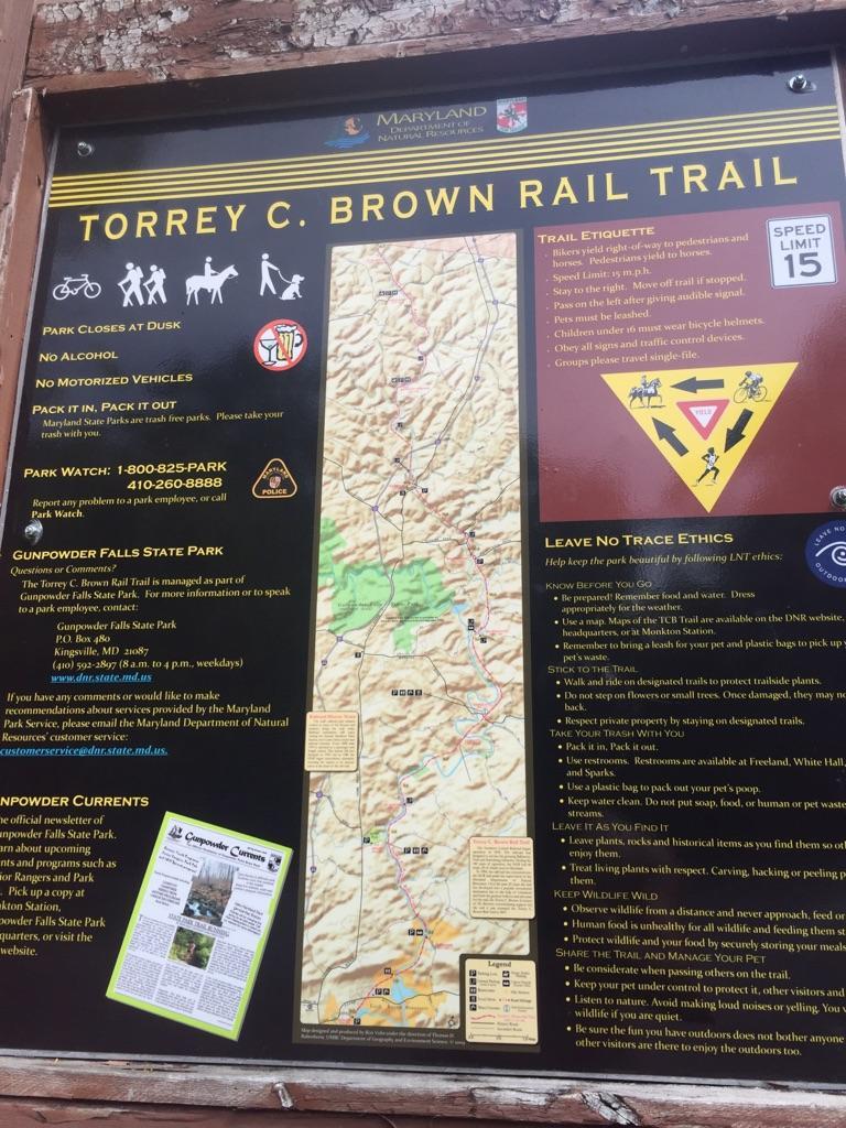 Close-up of a large information sign with maps and trail rules.