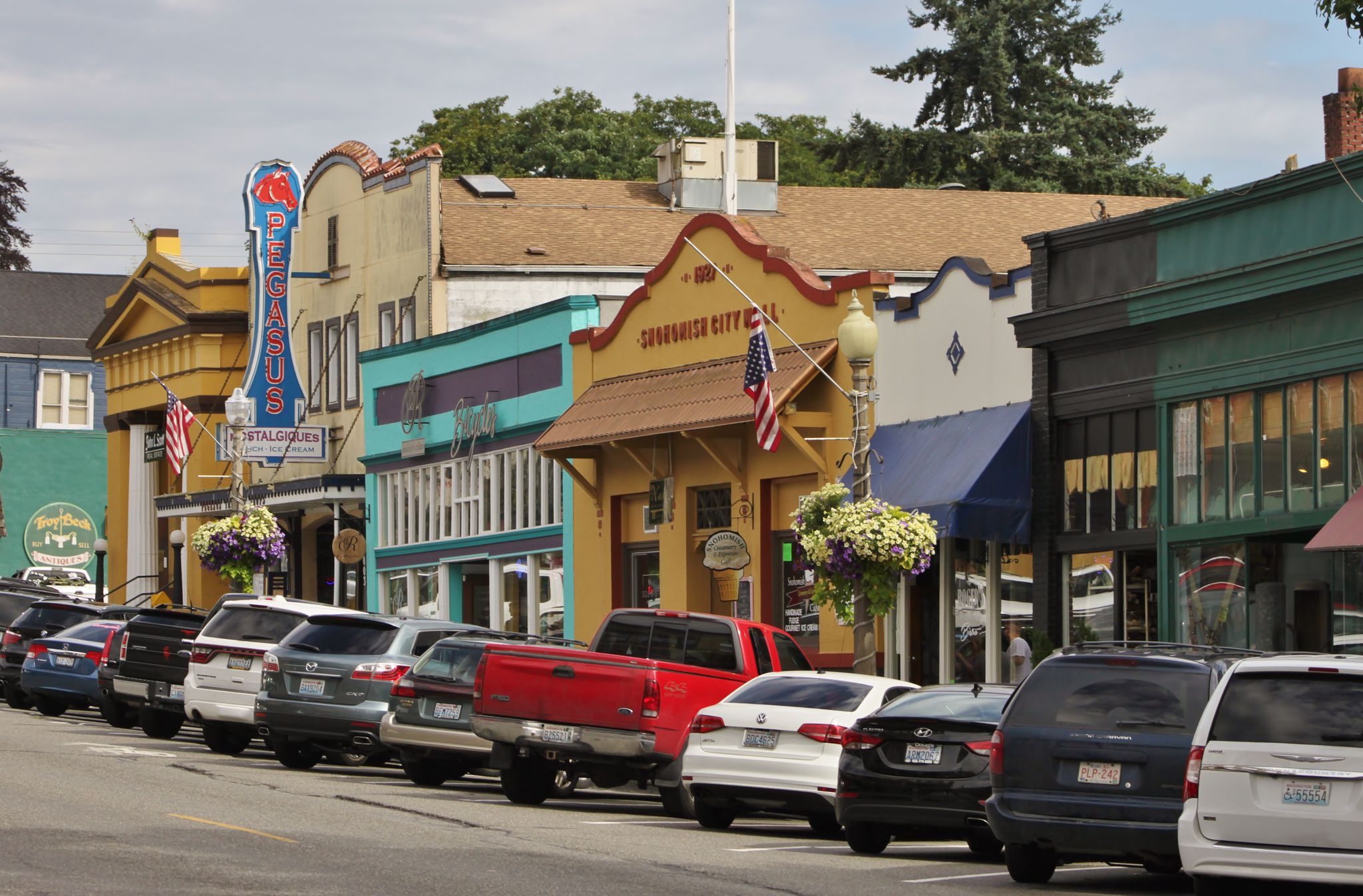 Colorful storefronts line a street with many cars parked along the curb. - Lowell Riverfront Park to Snohomish  via Lowell Riverfront Trail & Lowell Snohomish River Road
